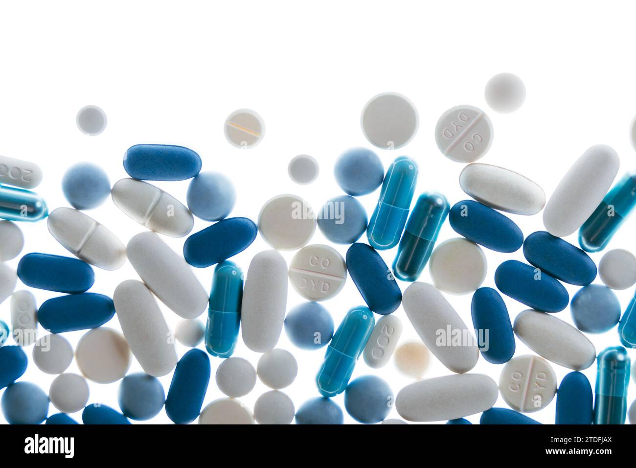 Pilules et comprimés bleus et blancs sur fond blanc Banque D'Images