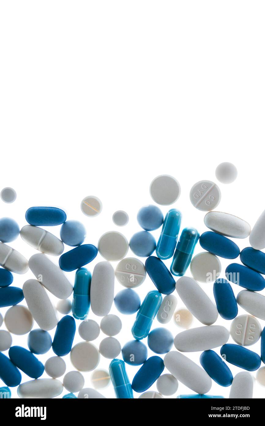 Pilules et comprimés bleus et blancs sur fond blanc Banque D'Images
