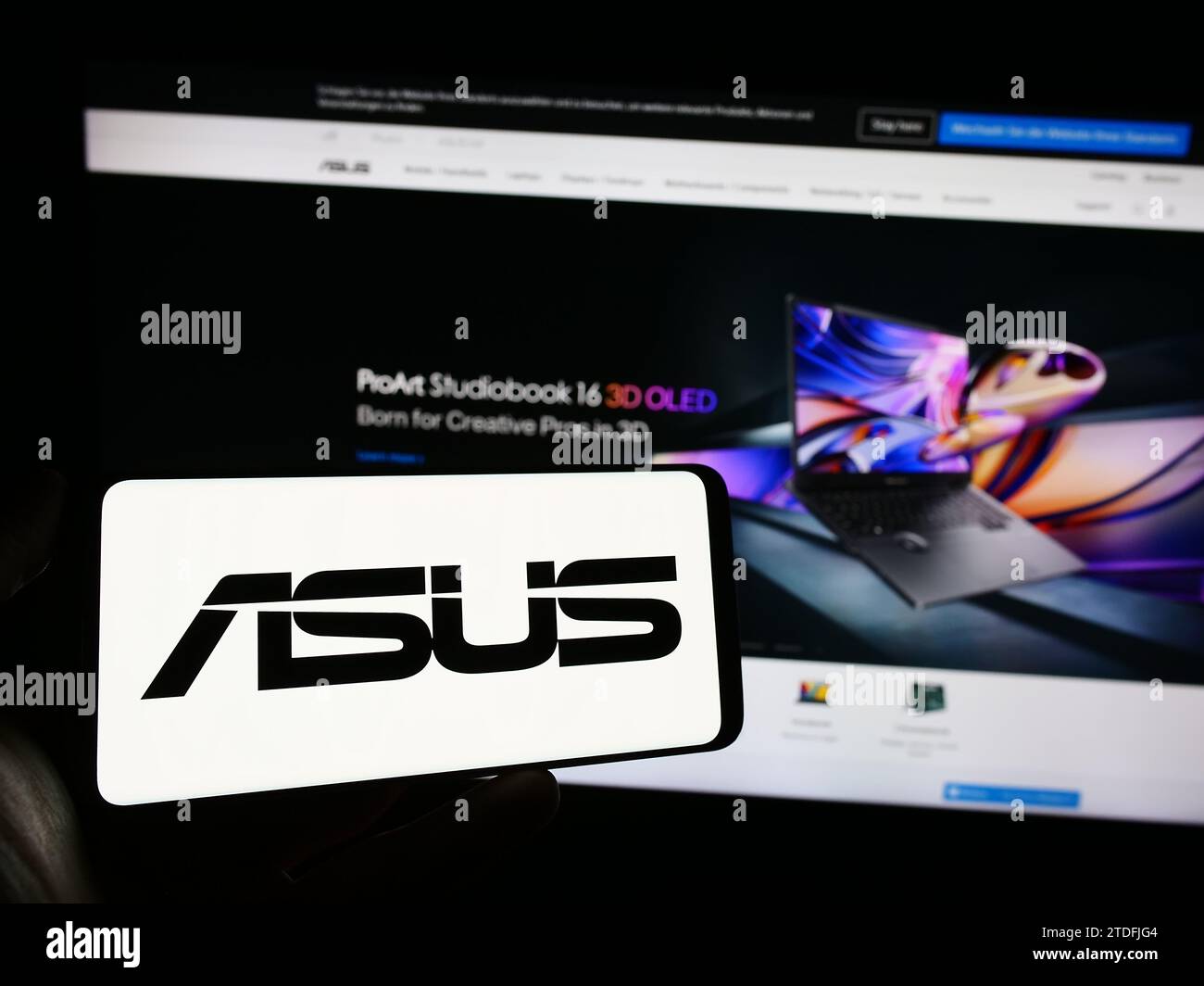 Personne tenant un téléphone portable avec le logo de la société taïwanaise ASUSTeK Computer Inc. (ASUS) devant la page Web de l'entreprise. Concentrez-vous sur l'affichage du téléphone. Banque D'Images