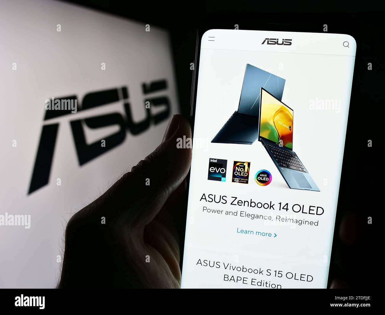 Personne détenant un téléphone portable avec le site Web de la société taïwanaise ASUSTeK Computer Inc. (ASUS) devant le logo. Concentrez-vous sur le centre de l'écran du téléphone. Banque D'Images