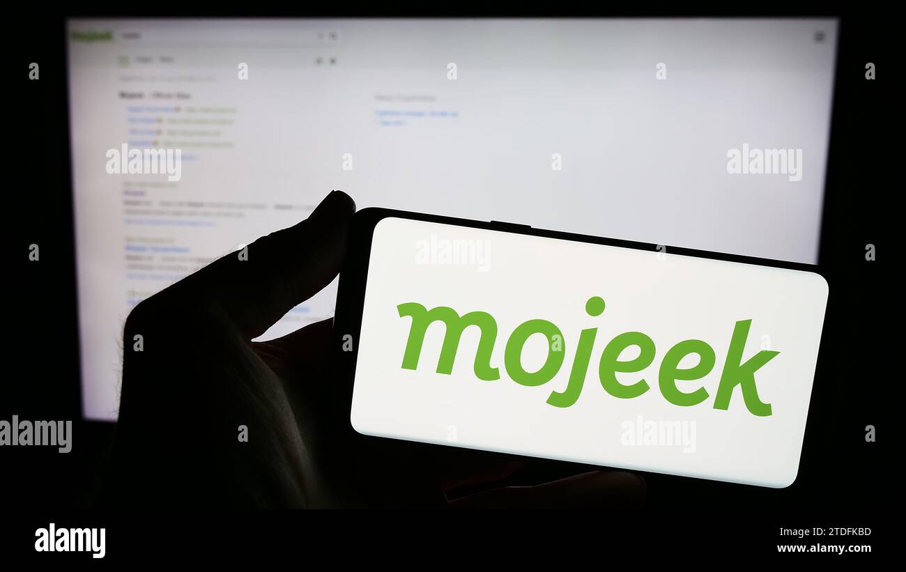 Personne tenant smartphone avec le logo de la société britannique de moteur de recherche en ligne Mojeek en face du site Web. Concentrez-vous sur l'affichage du téléphone. Banque D'Images