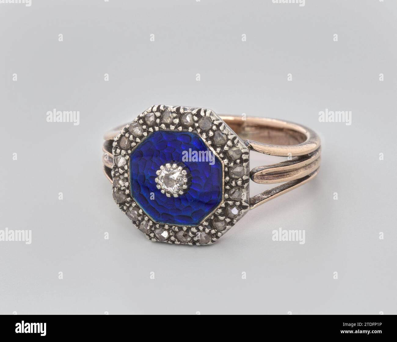 Cercle rose avec email bleu et diamant, anonyme, c. 1790 - c. 1810 bague rose argentée et dorée sertie de 20 diamants. Sur le dessus se trouve un disque octogonal criant avec de l'émail bleu cobalt avec un petit diamant taillé brillant au milieu. Le tibia lisse se divise en trois au sommet comme un motif de lys ou de feuilles. Or d'Angleterre (métal). argent (métal). diamant (minéral). Meulage / meulage Une bague rose argentée et dorée sertie de 20 diamants. Sur le dessus se trouve un disque octogonal criant avec de l'émail bleu cobalt avec un petit diamant taillé brillant au milieu. Le tibia lisse se divise en trois au sommet comme un lys ou Banque D'Images
