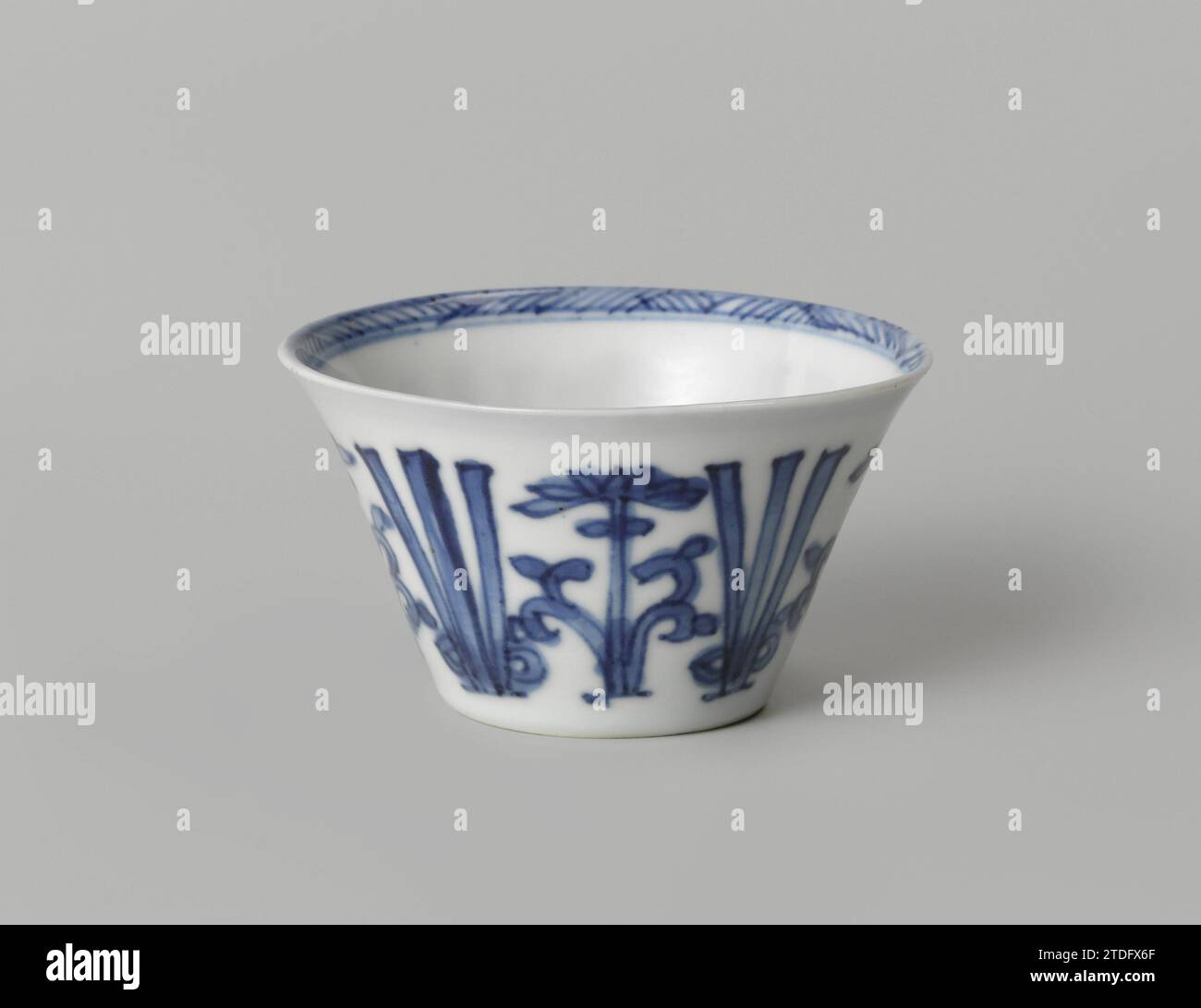 Tasse à fleurs stylisées, anonyme, c. 1700 - c. 1724 tête en porcelaine avec un mur étalé, peinte en bleu sous-laque. Sur le mur extérieur une bande avec des vignes de fleurs stylisées entrecoupées de trois lignes. Une rosette de fleurs stylisée sur le fond. Le bord intérieur avec une bande avec un motif en zigzag. Marqué sur le dessous avec la marque à quatre caractères de Keizer Yongzheng (?) Dans un double cercle. Bleu blanc. Porcelaine de Chine. glaçage. Cobalt (minéral) peinture / vitrification tête en porcelaine avec un mur d'étalement, peint en bleu sous-couche. Sur le mur extérieur une bande avec des vignes de fleurs stylisées entrecoupées Banque D'Images