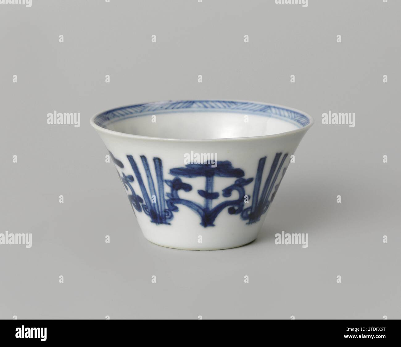 Tasse à fleurs stylisées, anonyme, c. 1700 - c. 1724 tête en porcelaine avec un mur étalé, peinte en bleu sous-laque. Sur le mur extérieur une bande avec des vignes de fleurs stylisées entrecoupées de trois lignes. Une rosette de fleurs stylisée sur le fond. Le bord intérieur avec une bande avec un motif en zigzag. Marqué sur le dessous avec la marque à quatre caractères de Keizer Yongzheng (?) Dans un double cercle. Bleu blanc. Porcelaine de Chine. glaçage. Cobalt (minéral) peinture / vitrification tête en porcelaine avec un mur d'étalement, peint en bleu sous-couche. Sur le mur extérieur une bande avec des vignes de fleurs stylisées entrecoupées Banque D'Images