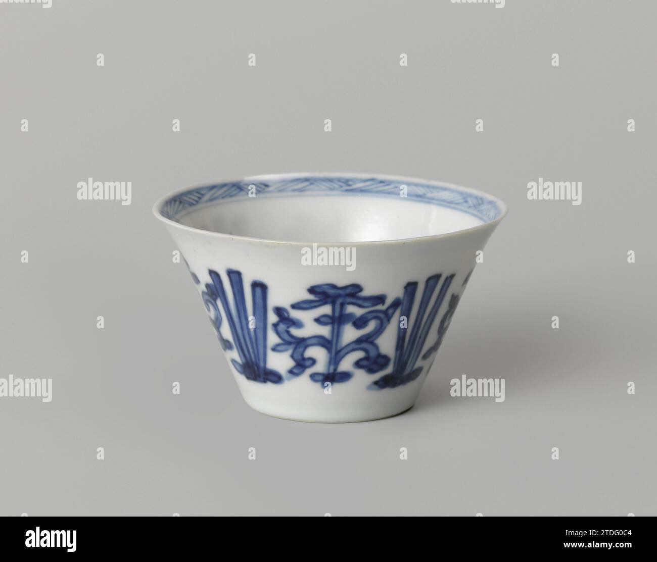 Tasse à fleurs stylisées, anonyme, c. 1700 - c. 1724 tête en porcelaine avec un mur étalé, peinte en bleu sous-laque. Sur le mur extérieur une bande avec des vignes de fleurs stylisées entrecoupées de trois lignes. Une rosette de fleurs stylisée sur le fond. Le bord intérieur avec une bande avec un motif en zigzag. Marqué sur le dessous avec la marque à quatre caractères de Keizer Yongzheng (?) Dans un double cercle. Bleu blanc. Porcelaine de Chine. glaçage. Cobalt (minéral) peinture / vitrification tête en porcelaine avec un mur d'étalement, peint en bleu sous-couche. Sur le mur extérieur une bande avec des vignes de fleurs stylisées entrecoupées Banque D'Images