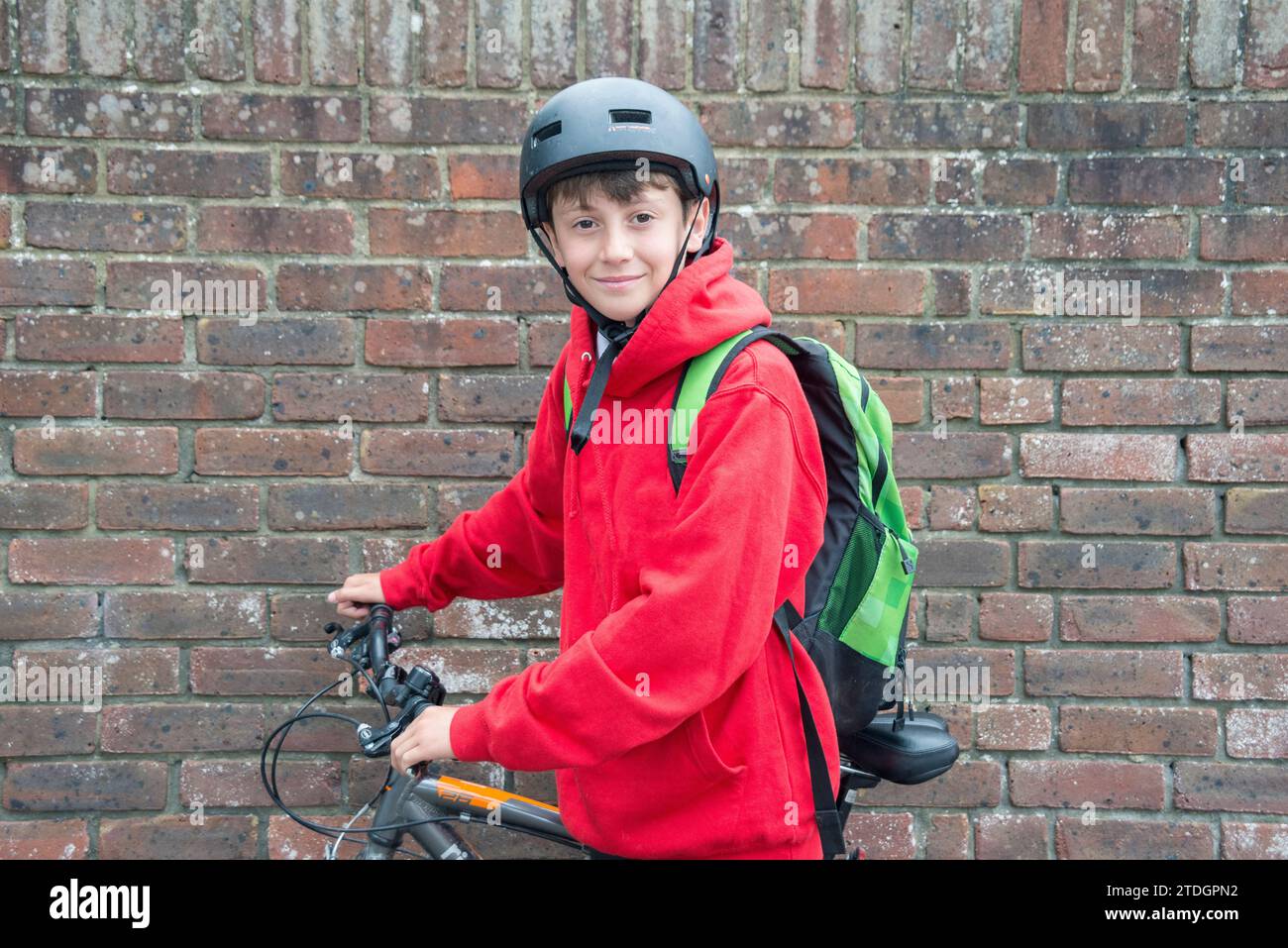 Un garçon avec son vélo prêt à voyager à l'école dans son uniforme Banque D'Images