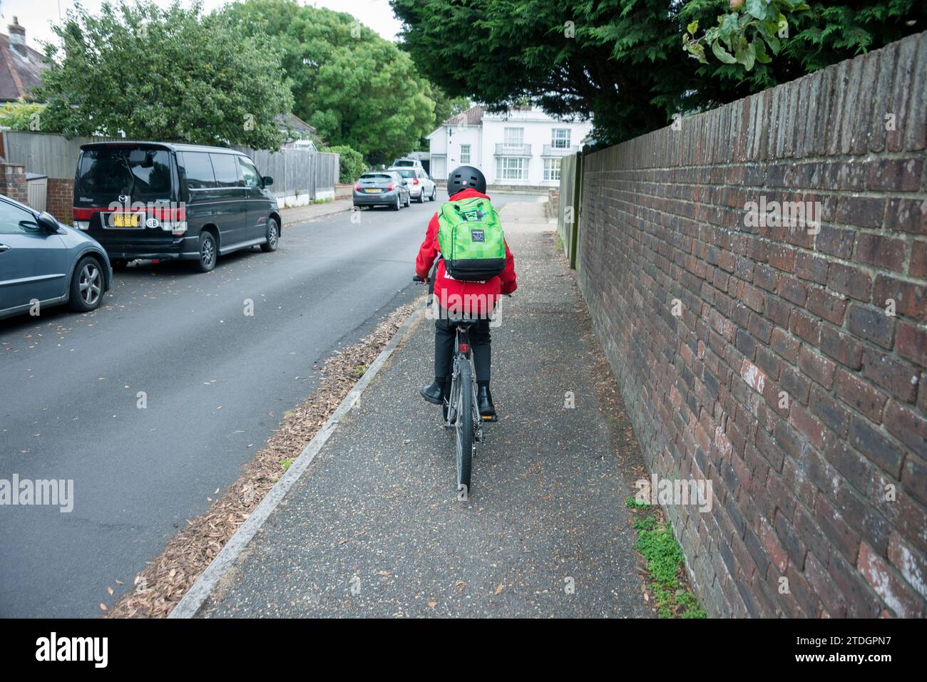 Un garçon avec son vélo prêt à voyager à l'école dans son uniforme Banque D'Images