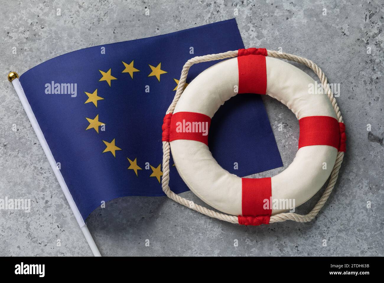 Drapeau et bouée de sauvetage de l'Union européenne sur un fond concret abstrait, concept sur le thème de l'assistance de l'Union européenne Banque D'Images