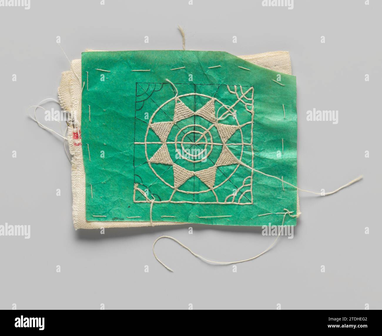 Propriété avec motif côté aiguille sur parchemin de couleur verte pour une réticelle quatre côtés avec surface double couche de lin et avec des lignes de traçage et des points côté aiguille, anonyme, c. 1920 Pick avec motif côté aiguille sur parchemin de couleur verte pour une réticelle quatre côtés. L'incitation est enfilée sur une double couche de lin (serviette de cuisine) et un début a été fait avec les lignes de traçage et le remplissage en pièces avec des points de côté aiguille par l'incitation et la couche inférieure. Deux aiguilles ont été mises dans la toile. Parchemin néerlandais (matériel animal). lin (matériel) dessin / barbotage / couture Pick Banque D'Images