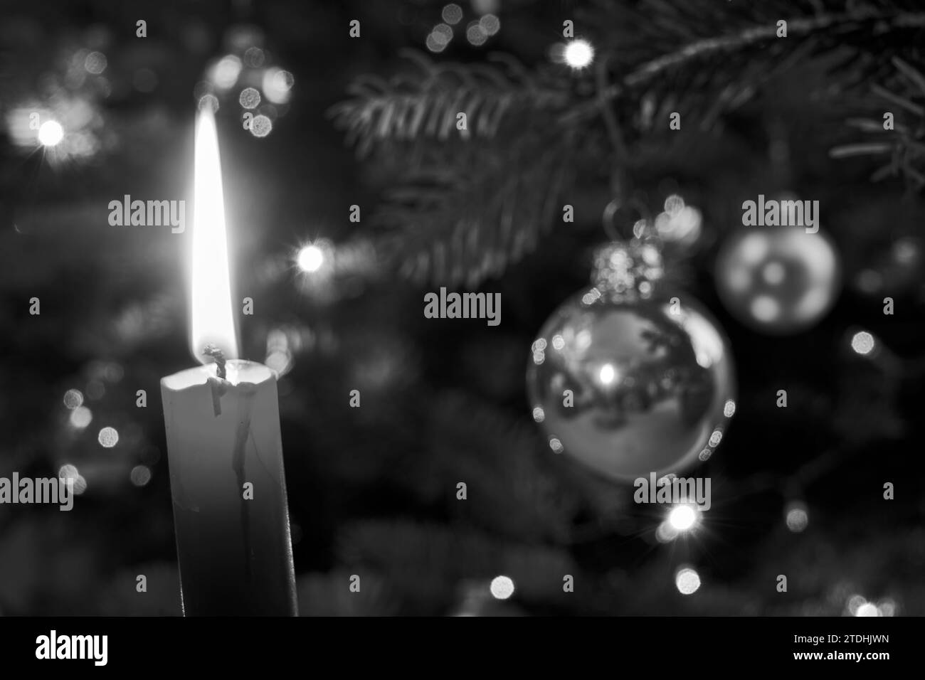 Flamme de bougie et décorations de Noël sur l'arbre pendant Noël, Pologne, monochrome Banque D'Images