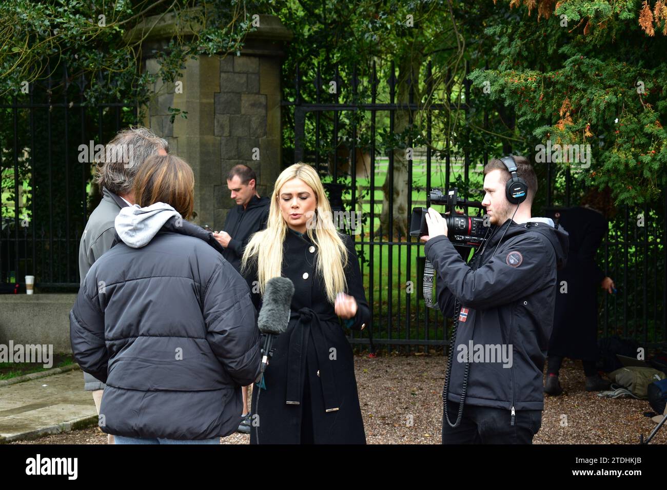 Jeune journaliste blonde et caméraman interrogeant un couple devant le château de Windsor après la mort de la reine Elizabeth II Banque D'Images