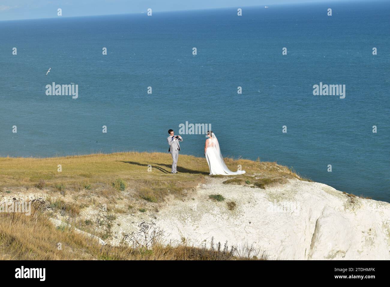 Couple nouvellement marié tenant une séance photo au sommet des falaises blanches pittoresques de Douvres Banque D'Images