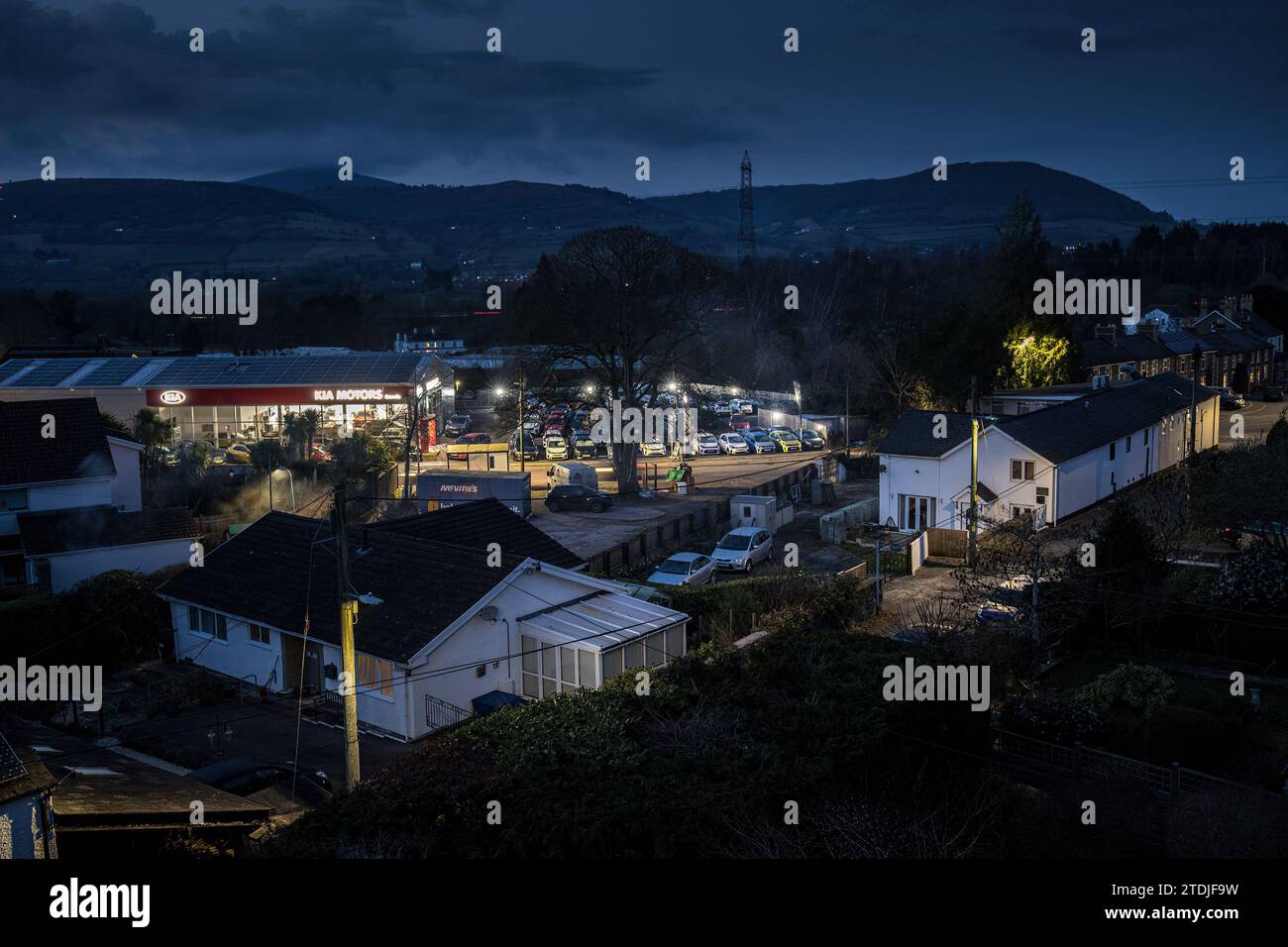 Village la nuit avec des lampadaires et des maisons et la pollution lumineuse du showroom de voiture, Llanfoist, pays de Galles, Royaume-Uni Banque D'Images