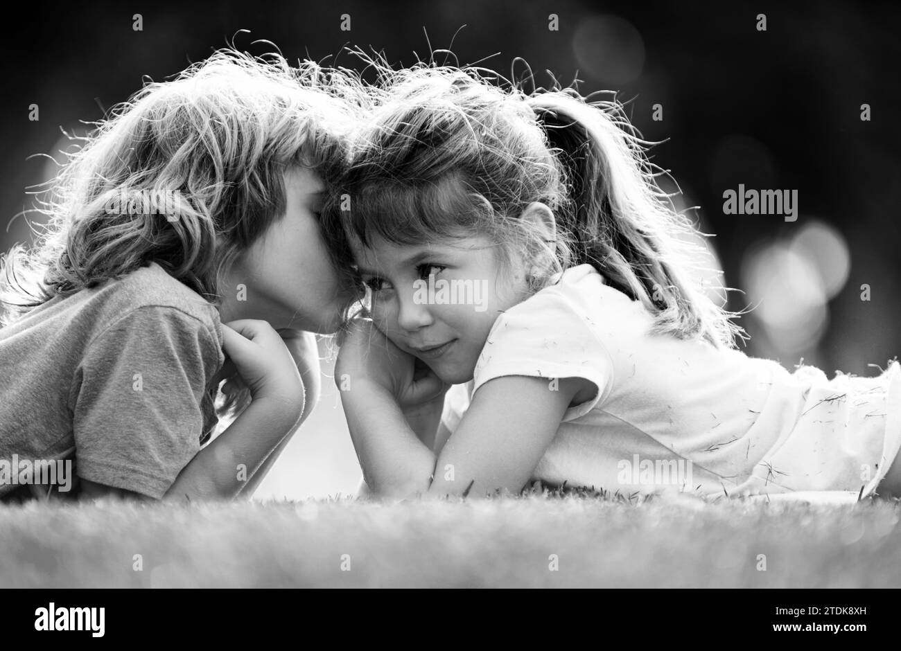 Couple d'enfants embrassant et embrassant. Petits enfants adorables à l'extérieur. Enfants dans le parc d'été, en gros plan. Les enfants aiment ensemble. Petite fille embrassant Banque D'Images