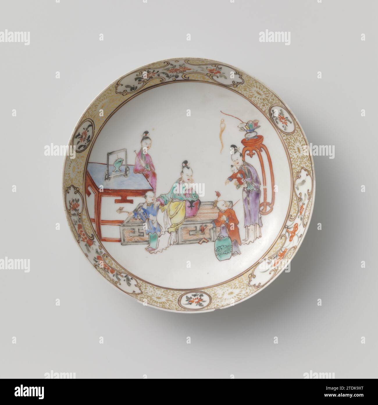 Soucoupe-plat avec trois femmes et enfants avec des objets précieux, anonyme, c. 1740 - c. 1760 bol en porcelaine avec mur rond, peint sur la glaçure en bleu, rouge, rose, vert, jaune, violet, noir et or. Sur le devant trois femmes avec trois enfants avec des objets de valeur; une femme debout à côté d'une table, une femme assise à côté d'elle un enfant avec sceptique, un enfant avec une pierre musicale sur un bâton grimpe sur un tabouret, une femme avec un enfant sur le bras, derrière elle un tabouret haut avec vase; le bord intérieur avec des vignes de fleurs entrecoupées de cartouches rondes et de forme fantaisiste avec des branches de fleurs. Une puce et Banque D'Images