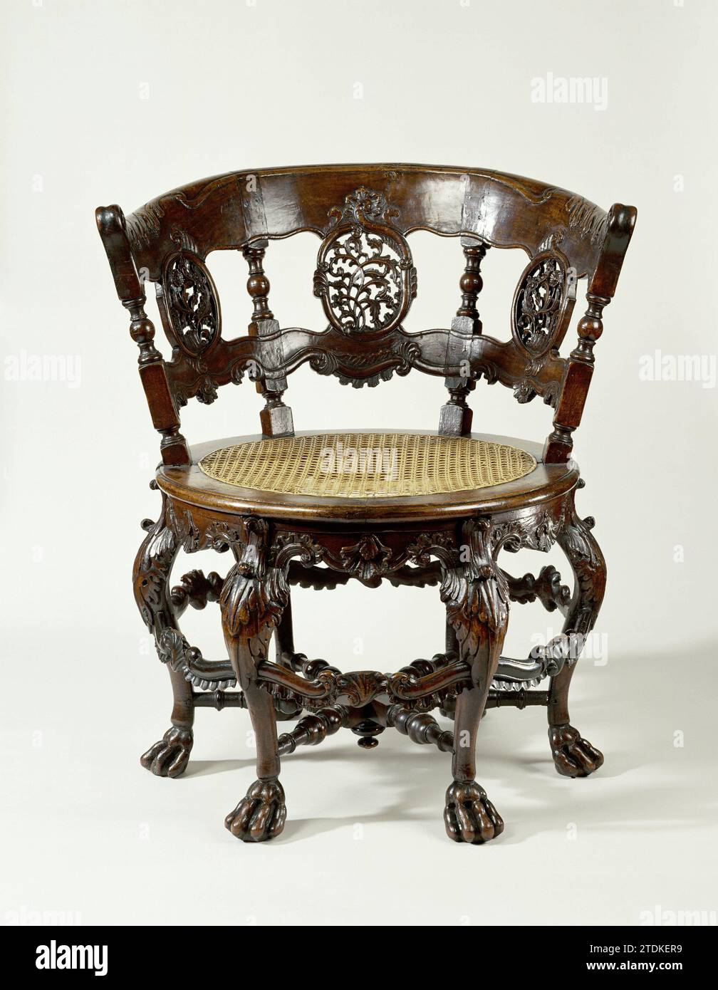 Chaise, ronde, sur six pieds en forme de S sur griffes, avec travail de feuilles poignardées et motifs rocaille. Dos avec quatre styles entre lesquels trois champs avec travail de feuille ajourée., Anonyme, 1750 chaise de bois tropical. Les six pattes en forme de S sur les griffes sont décorées au-dessus des gonflements avec un travail de feuilles poignardées et sont reliées en bas par une croix placée en rayon. Le voor-Midden Sports montre un palmier avec rocaille-voluten. La règle festonnée de la ronde, avec des roseaux tendus de fenêtre assise est décorée de motifs rocaillem. Le dos se compose de quatre styles avec maison et section et deux coquilles Saint-Jacques, entre lesquelles th Banque D'Images