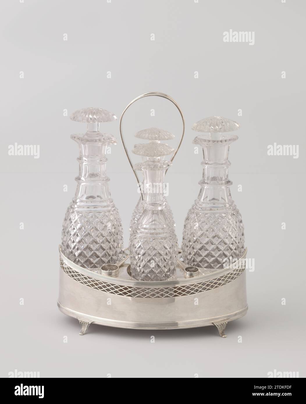 Huile et vinaigre avec quatre bouteilles dans un support précipité, Fa. Diemont, 1801 le support ovale Striker a des parois droites légèrement surélevées sur les côtés. Il repose sur quatre, rajeunissant, pliés, jambes nervurées. Il y a des embouteillages au-dessus de ces jambes et le long du dessus du support. Un bord ajouré de la grille est installé sous le bord supérieur. Le long de l'intérieur du bord supérieur, il y a quatre saillies voûtées, sur lesquelles repose l'insert. Il se compose d'une plaque avec quatre grands évidements pour les bouteilles de verre incolore et aiguisé et quatre plus petits pour les arrêts. Par le centre de cette plaque, Banque D'Images