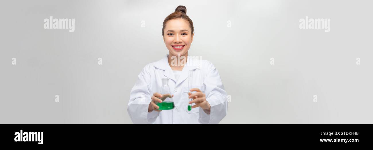 Female scientist in lab coat avec un produit chimique de la verrerie. Isolé sur blanc. Banque D'Images