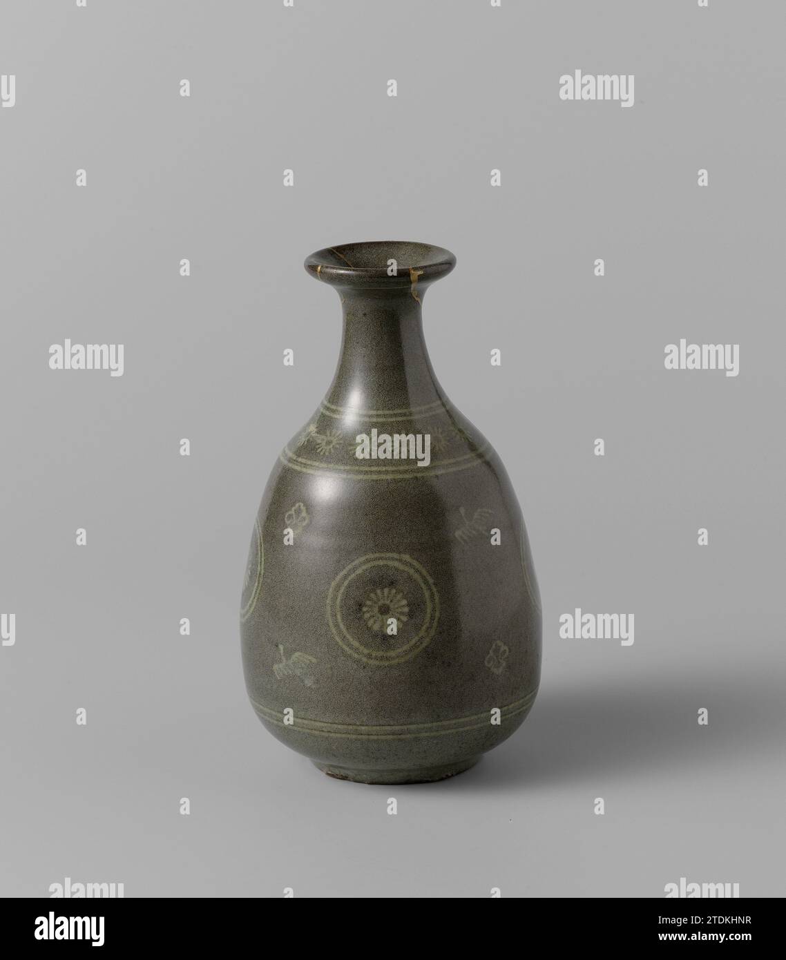 Vase bouteille avec des fleurs stylisées en médaillons, oiseaux et bordures ornementales, anonyme, c. 1600 - c. 1800 vase en forme de bouteille en grès, recouvert de blanc inséré avec un glaçage celladongroen. Le vase a un corps en forme d'oeuf et un étroit, vers le haut. Sur le ventre quatre fois une fleur stylisée dans un médaillon avec un oiseau et une feuille entre les deux. Sur l'épaule une bande avec des fleurs stylisées. Le vase a quelques fissures qui ont été restaurées avec de la laque dorée. Karatsu. Grès japonais. Incrustation de glaçure (procédé) / peinture / vitrification vase en forme de bouteille en grès, recouvert de blanc i Banque D'Images