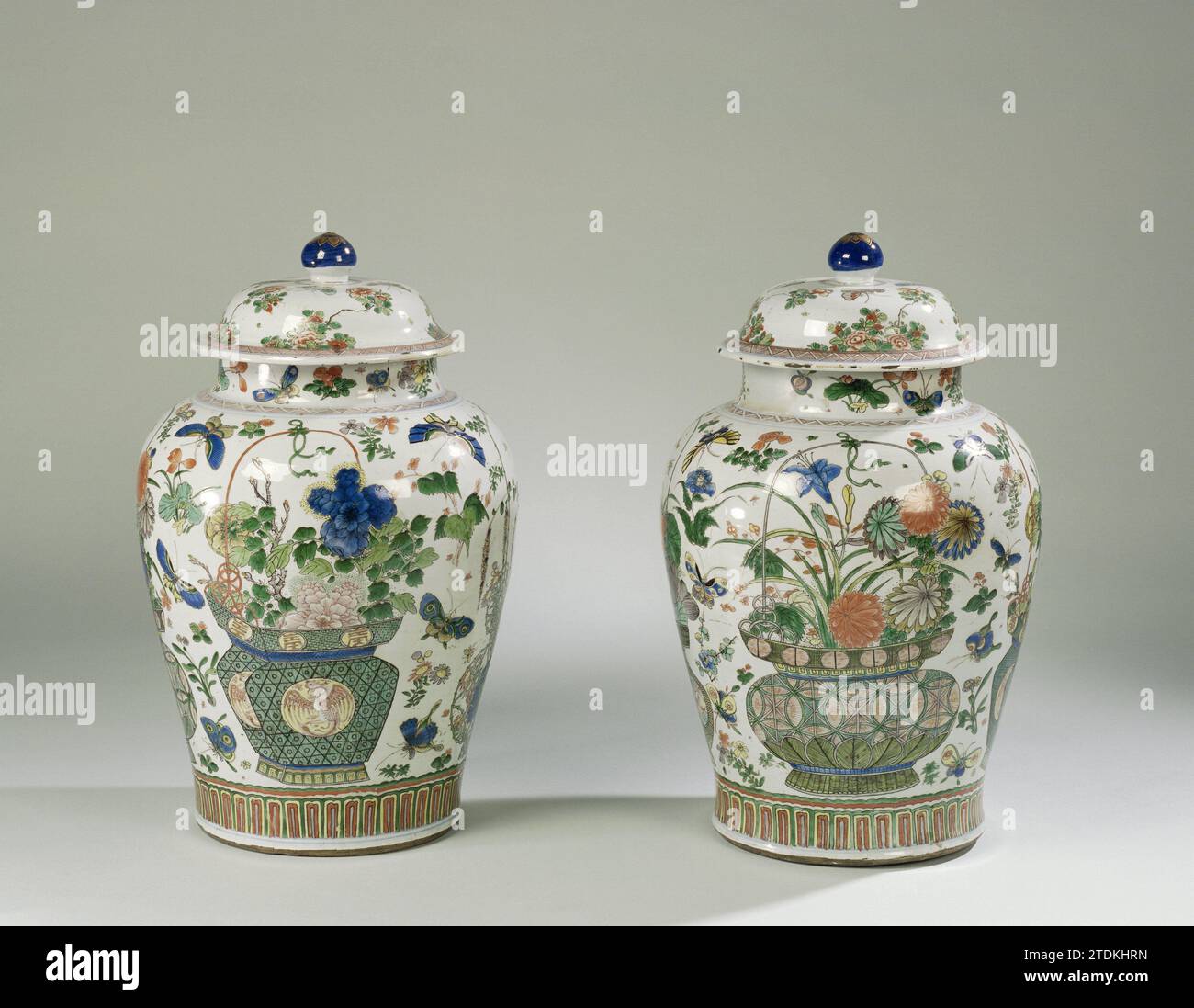 Pot couvert de balustre avec paniers de fleurs, sprays de fleurs et insectes, anonyme, c. 1700 - c. 1724 pot de couvercle en porcelaine en forme de balus, peint sur la glaçure en bleu, rouge, vert, jaune, aubergine, noir et or. Sur le ventre quatre fois un panier de fleurs avec aster, pivoine, prunus, pluie bleue, lotus, chrysanthème et iris. Un panier avec des motifs Shishi et Ruyi et un panier avec des Feng Huangs et des caractères chinois. Entre les paniers, les branches de fleurs lâches et les insectes. Au-dessus du pied une bande avec des motifs de feuilles stylisés. Sur l'épaulement un lien avec le travail de l'arbre. Le cou avec des branches de fleurs et des papillons Banque D'Images