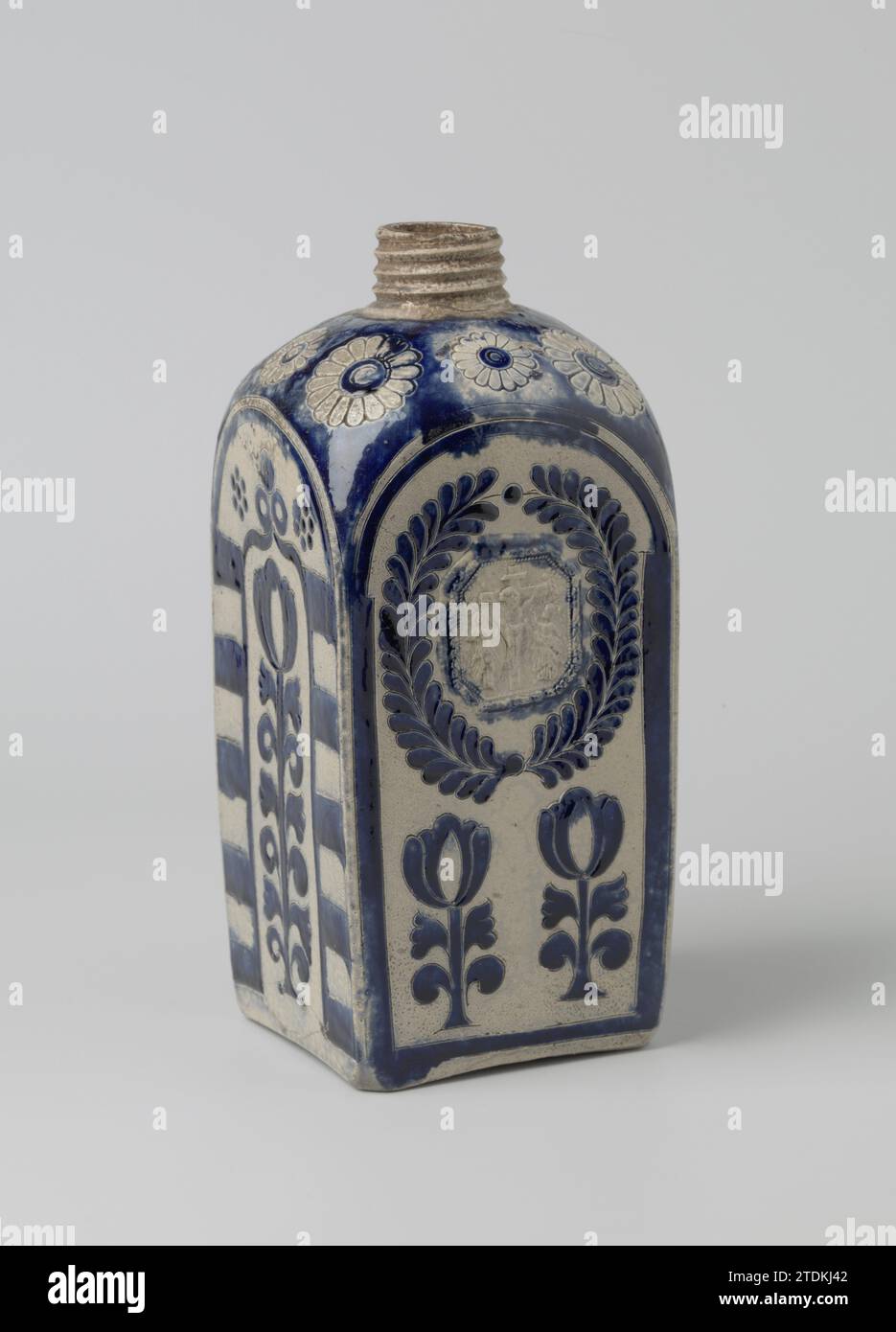 Bouteille carrée avec la Crucifixion et fleurs stylisées, anonyme, c. 1750 - c. 1799 bouteille de grès avec un corps carré, épaule arrondie et col étroit avec fil. Partiellement recouvert de bleu cobalt. D'un côté un petit relief imprimé et imposé de la crucifixion avec deux Maria comprend par un souffleur. Ci-dessous deux fleurs stylisées. Les trois autres côtés avec une fleur stylisée à long terme dans une sorte de porte. Rosettes estampées sur l'épaule sauvées en bleu. DOP manquant. Westerwald. Grès Westerwald. glaçage. Bouteille de vitrification cobalt (minérale) en grès à corps carré, r Banque D'Images