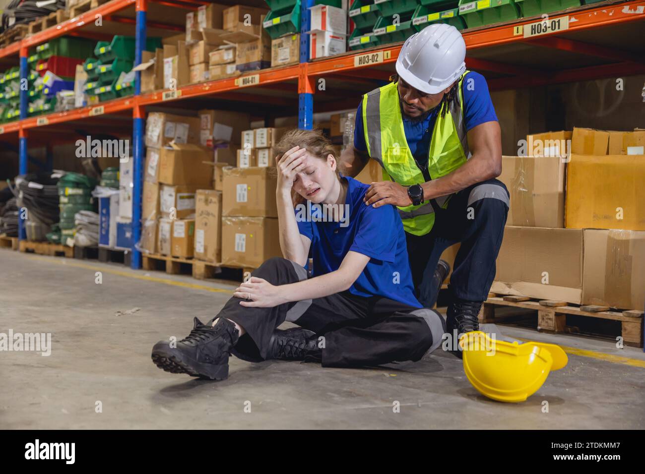 Le travailleur des femmes d'entrepôt se sent vers le bas, accident de blessure et blessé fille pleurant ami superviseur aider à soutenir. Banque D'Images