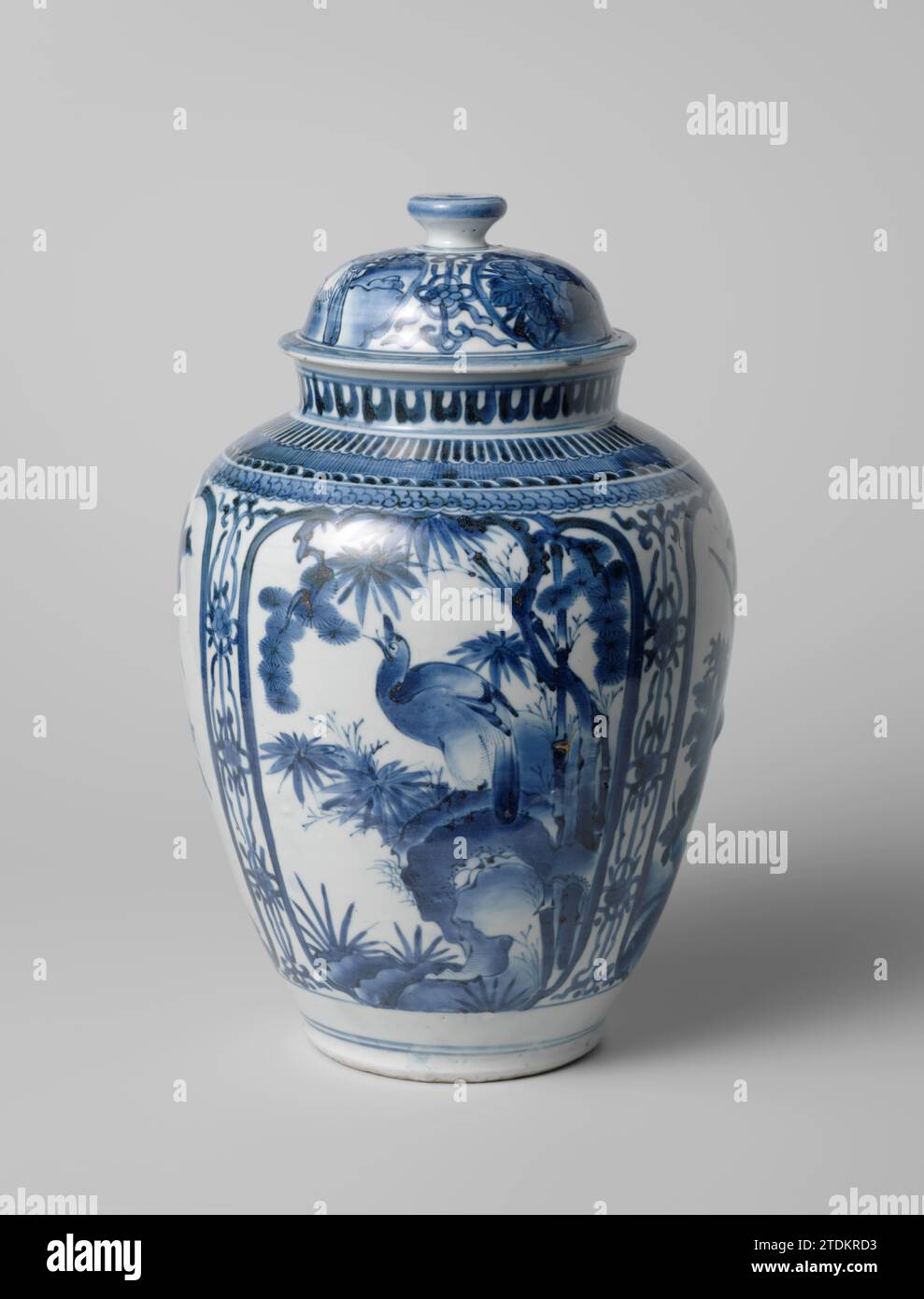 Pot couvert ovoïde avec un oiseau sur un rocher et des plantes à fleurs en panneaux, anonyme, c. 1650 - c. 1680 couvercle en porcelaine d'un pot à couvercle en forme d'oeuf, peint en bleu sous-laque. Sur le mur deux cartouches festonnées avec un oiseau sur un rocher en plantes dans l'une (pin, bambou), et dans l'autre une plante à fleurs (pivoine) dans un rocher. Vignes de fleurs stylisées entre les cartouches. Sur le bouton une fleur stylisée. Le couvercle avec la même décoration. Le couvercle a été cassé. Bleu blanc. Porcelaine du Japon. glaçage. Cobalt (minéral) peinture / vitrification couvercle en porcelaine de pot à couvercle en forme d'oeuf, peint en bleu sous-laque. Sur le mur Banque D'Images