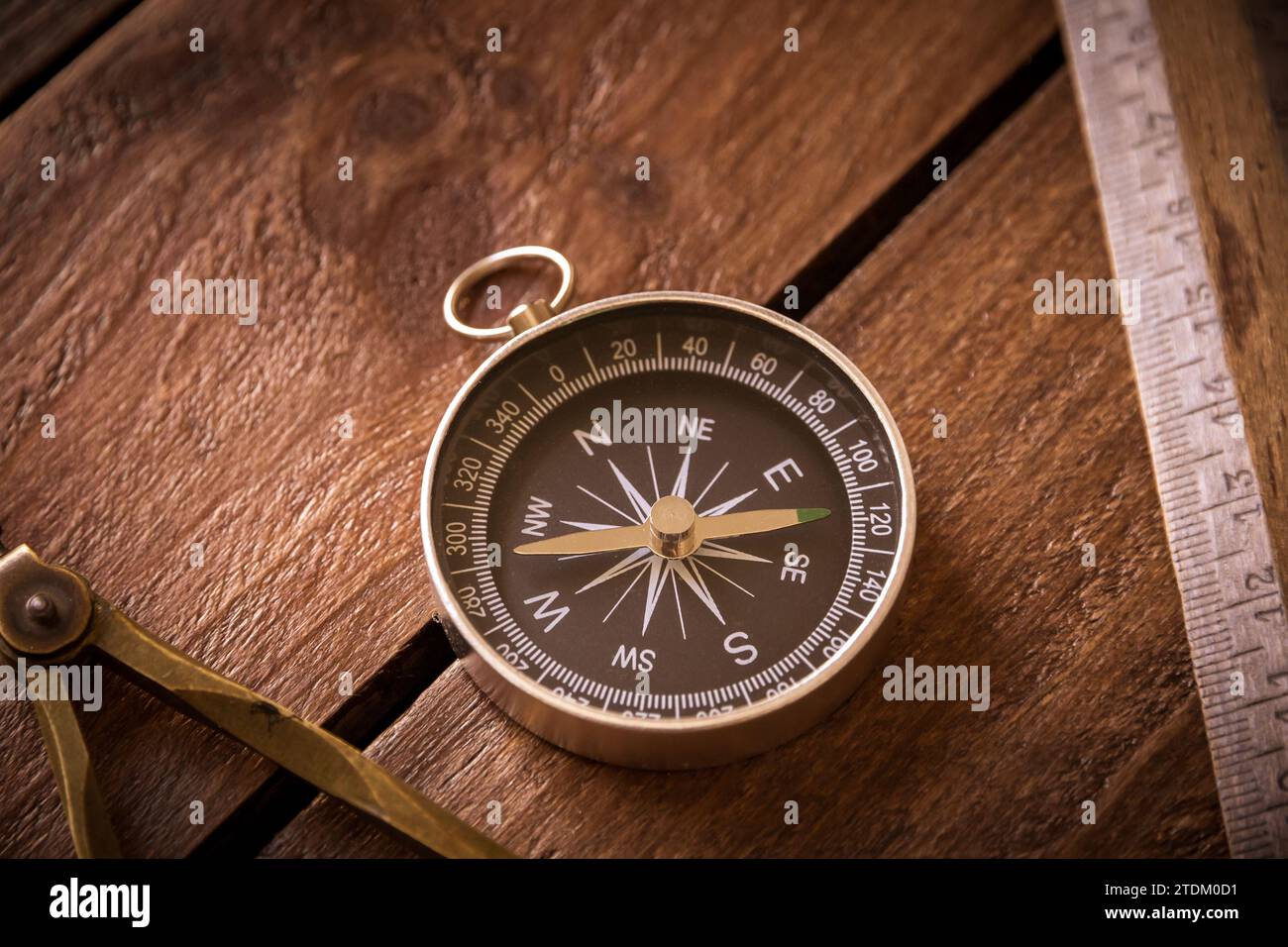 Règle vintage, dessin et boussole de navigation sur une planche de bois rustique Banque D'Images