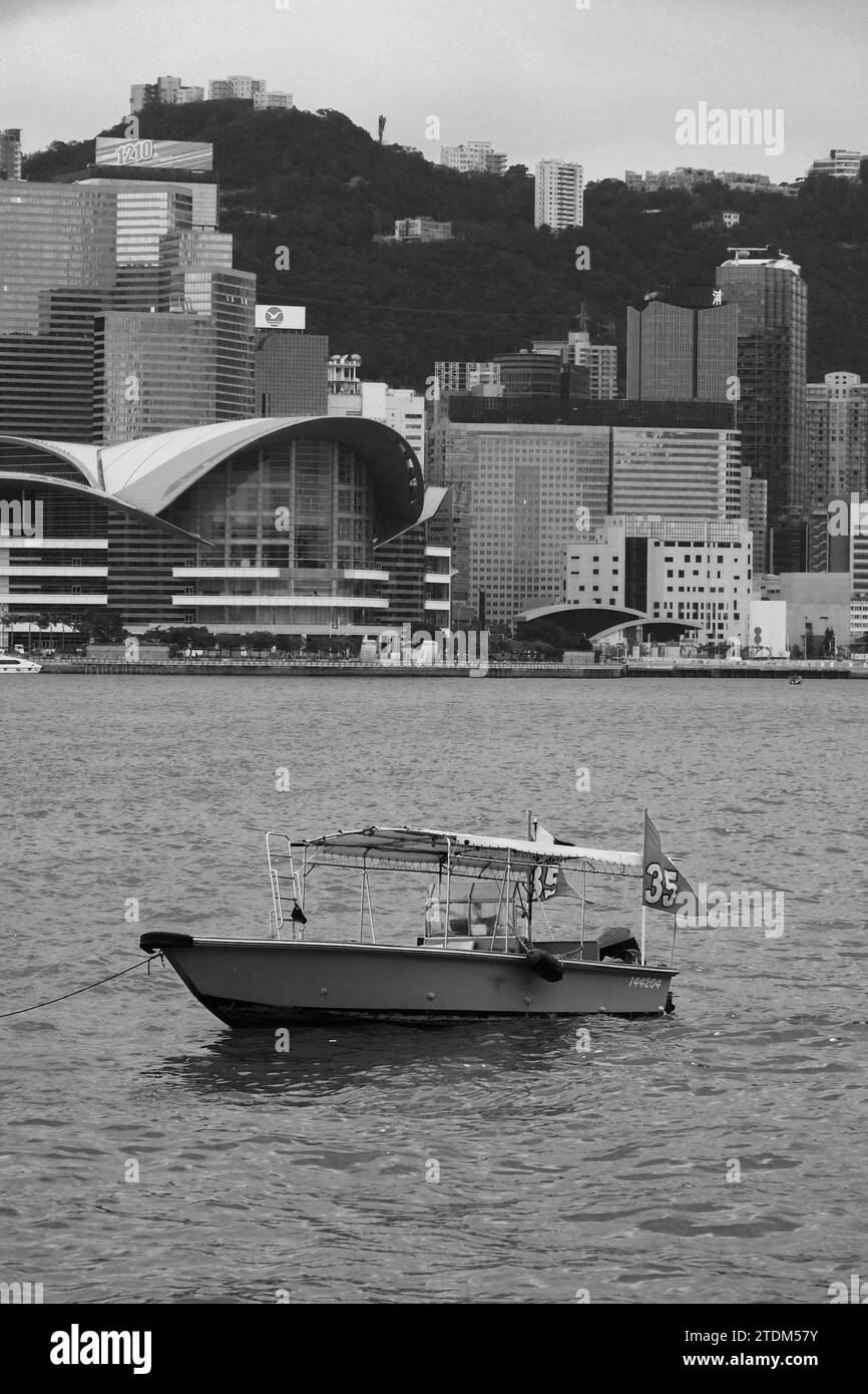 Silence sur le port : un bateau vide flottant sur les eaux du port Victoria, Hong Kong Banque D'Images