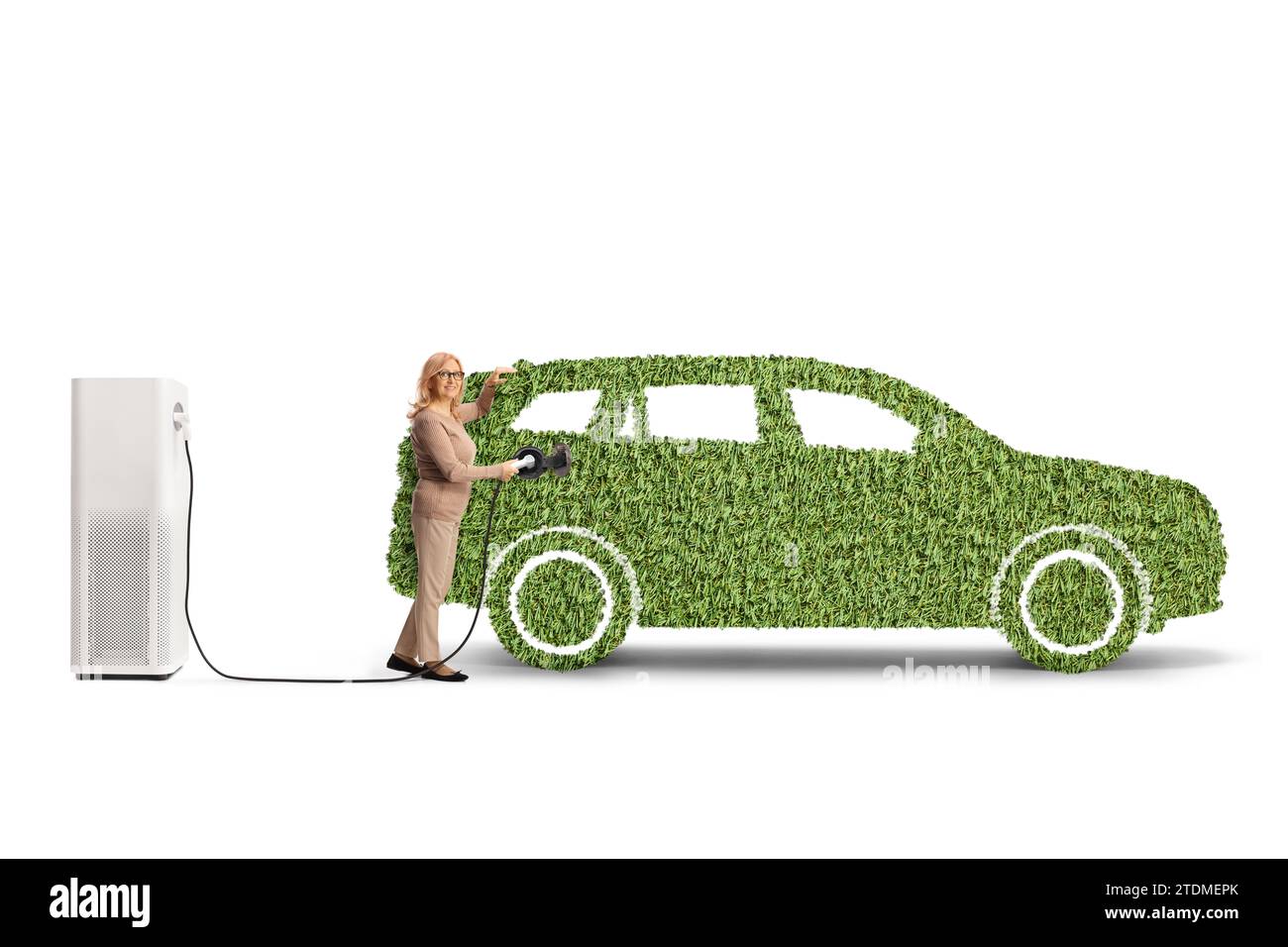 Femme chargeant un SUV électrique en herbe verte isolé sur fond blanc Banque D'Images