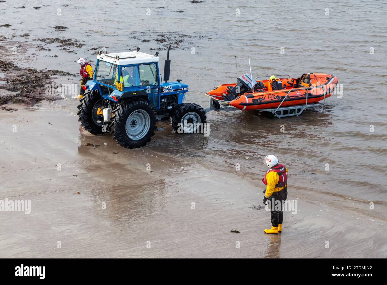 Embarcation de sauvetage RNLI de classe D sur remorque tirée hors de la mer par un tracteur. Banque D'Images