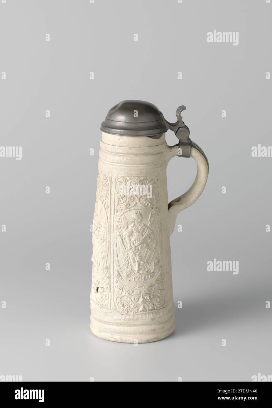 Tankard (schnelle) avec Judith, anonyme, c. 1570 - c. 1600 carafe (schnelle) en grès avec corps cylindrique, conique et oreille en forme de C. Profils sous le bord et au-dessus du pied. Sur le corps en relief trois fois une boîte allongée imprimée et imposée avec Judith dans un médaillon, 'Ivdith', avec la tête d'Holophernes. Les médaillons sont entourés de boucles et de vignes fleuries. La verseuse est prise dans un cadre en étain avec couvercle. Siegburg. Siegburg Stoneware. Glaçage. Monture : pichet de vitrification en étain (métal) (schnelle) en grès avec corps cylindrique conique et oreille en forme de C. Profils sous l'arête et ab Banque D'Images