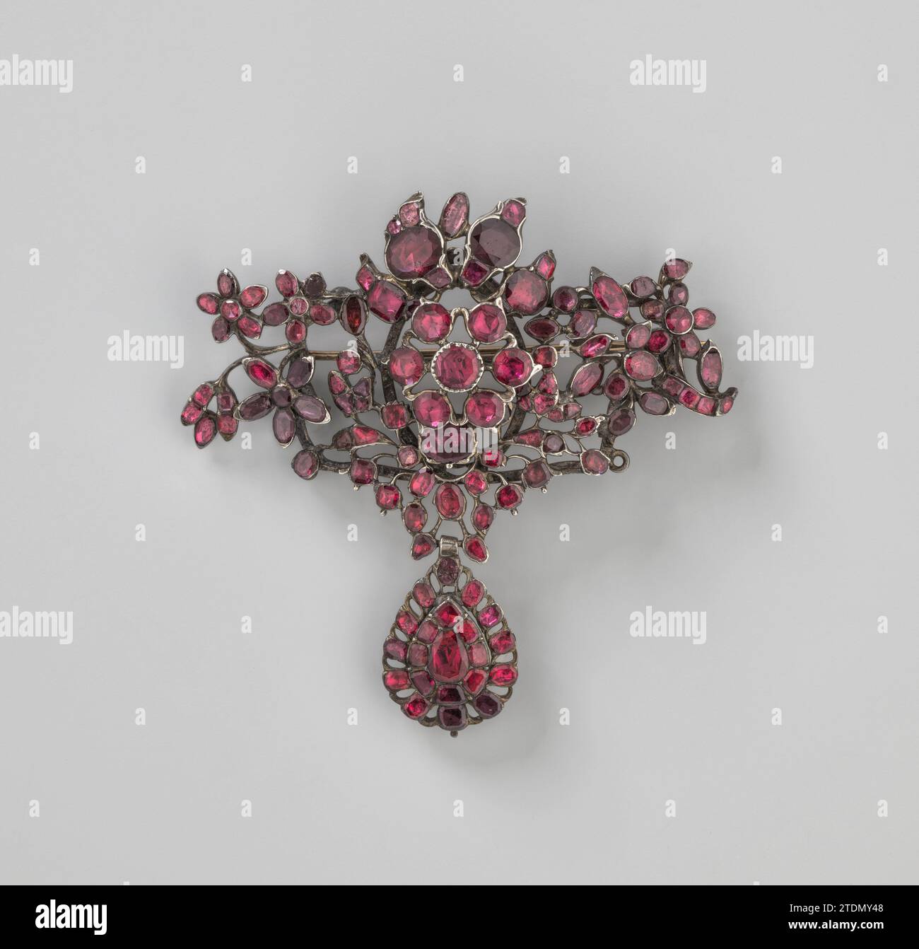 Broche en motif floral avec pendentif en forme de goutte, anonyme, 1770 - 1790 broche en argent et grenades en motif floral avec pendentif en forme de goutte. Les grenades sont posées sur une feuille d'argent. Il y a probablement deux pendentifs en forme de goutte qui ont été attachés de chaque côté du pendentif central. Deux yeux sont visibles à l'arrière de la broche avec laquelle la broche pourrait être attachée aux vêtements. La brochure du crochet date d'une date ultérieure. Argent Angleterre (métal). grenat (minéral) broche en argent et grenades à motif floral avec pendentif en forme de goutte. Les grenades sont posées sur une feuille d'argent. Il y a p Banque D'Images