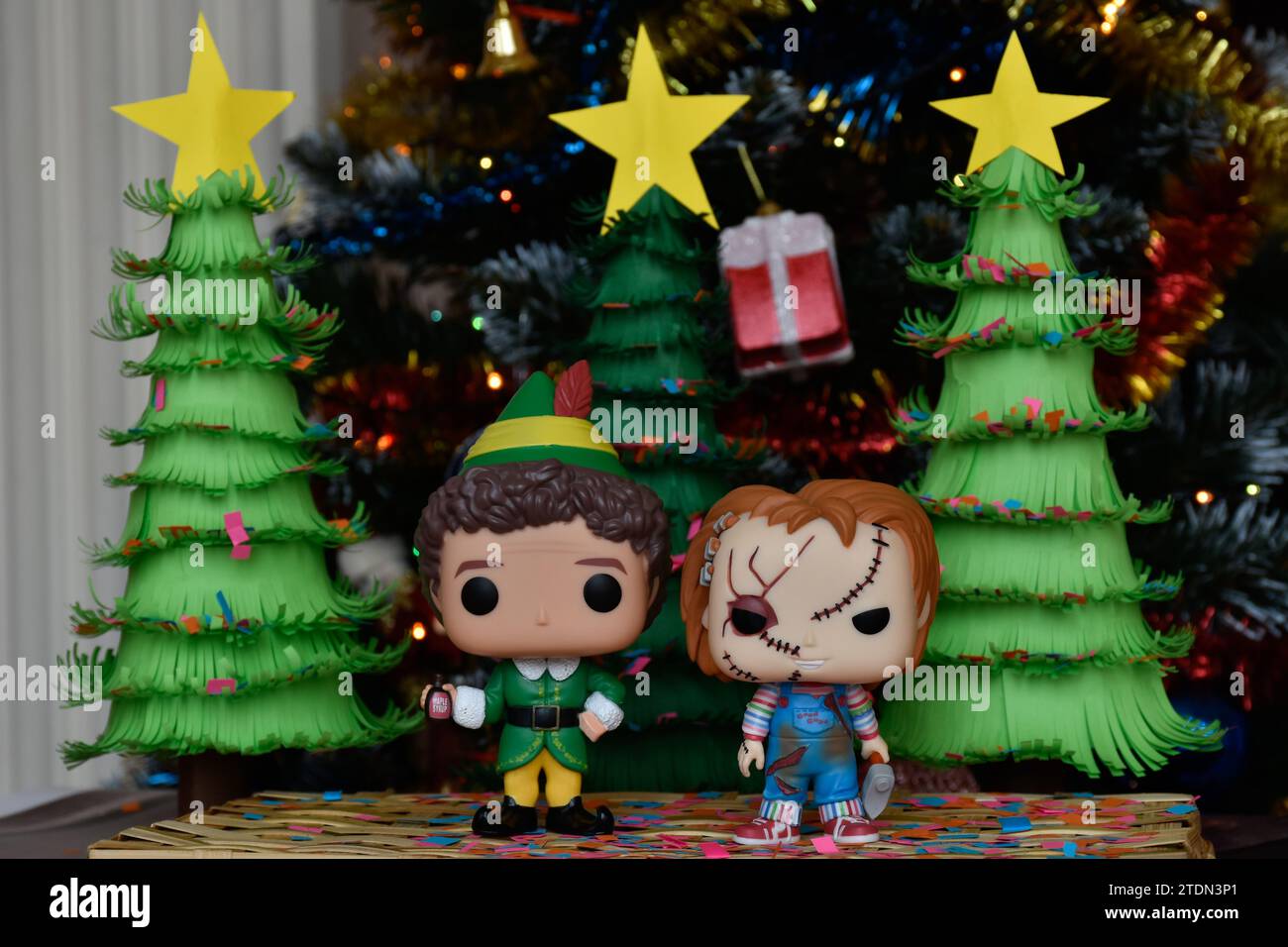 Figurines Funko Pop de Buddy l'elfe et Chucky tueur poupée. Arbres de Noël en papier faits à la main, ornements, confettis, guirlande, décor festif. Banque D'Images
