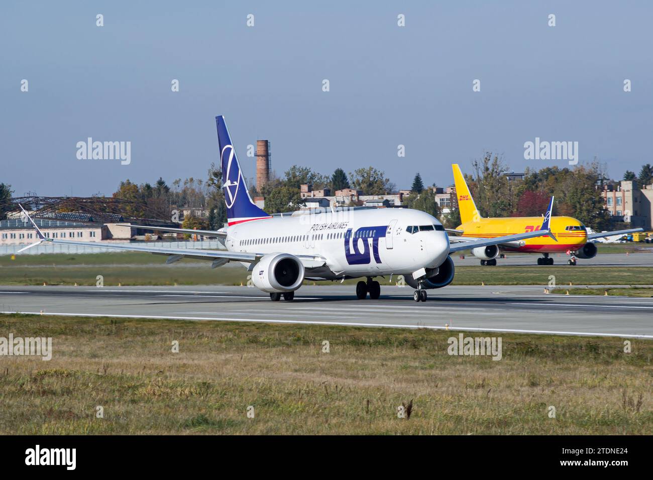LOT Polish Airlines Boeing 737 MAX 8 ralentit après avoir atterri à Lviv après un vol de Varsovie, Pologne. DHL Boeing 767-200F en arrière-plan Banque D'Images