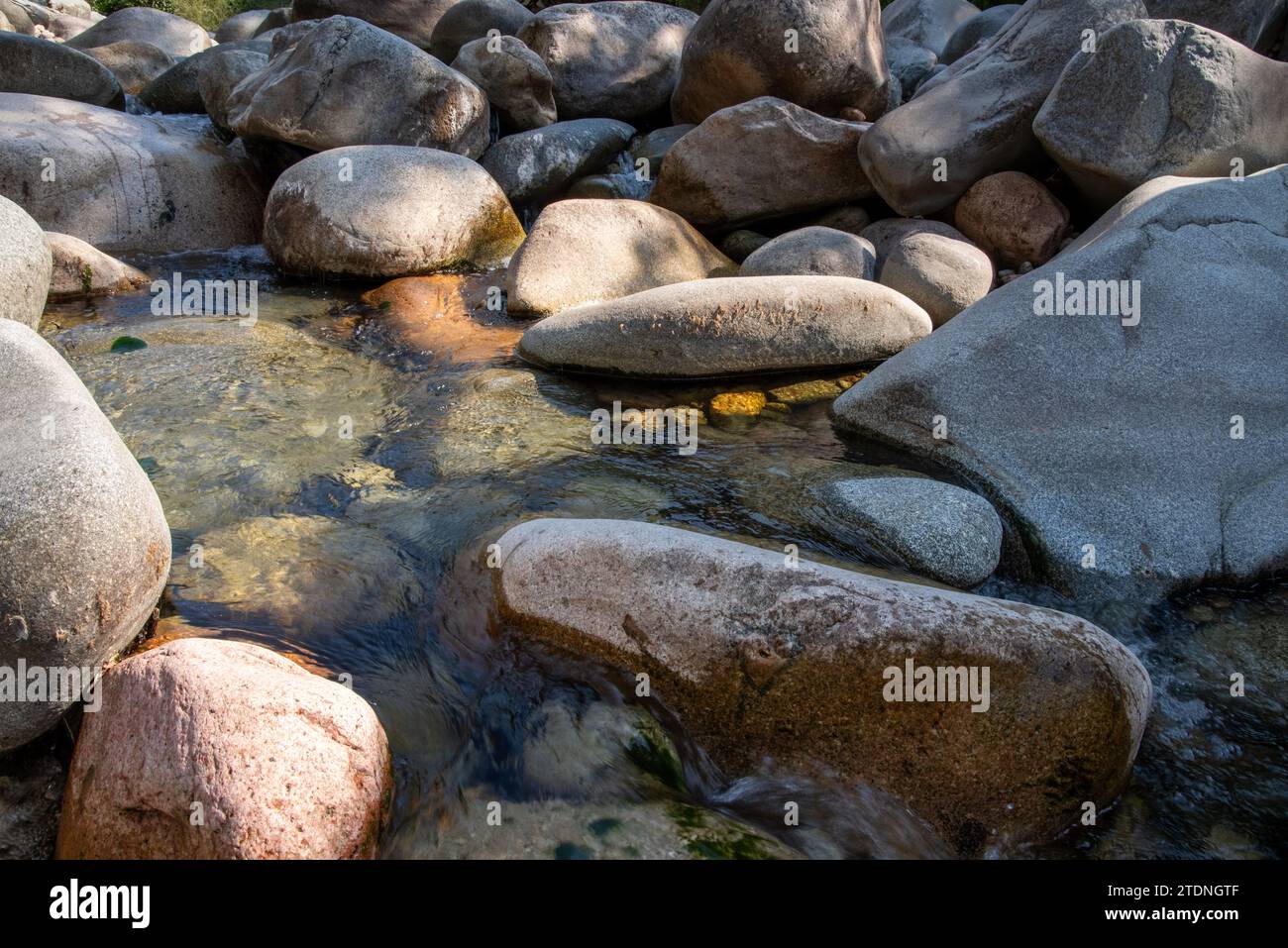 Scène de débit de ruisseau d'eau douce et roche dure de rivière naturelle avec lichen, petite vague et arrière-plan de réflexion de lumière Banque D'Images