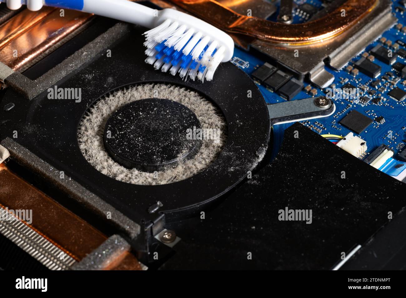 Ventilateur d'ordinateur portable sale plein de poussière et doit être nettoyé à l'aide d'une brosse à dents Banque D'Images