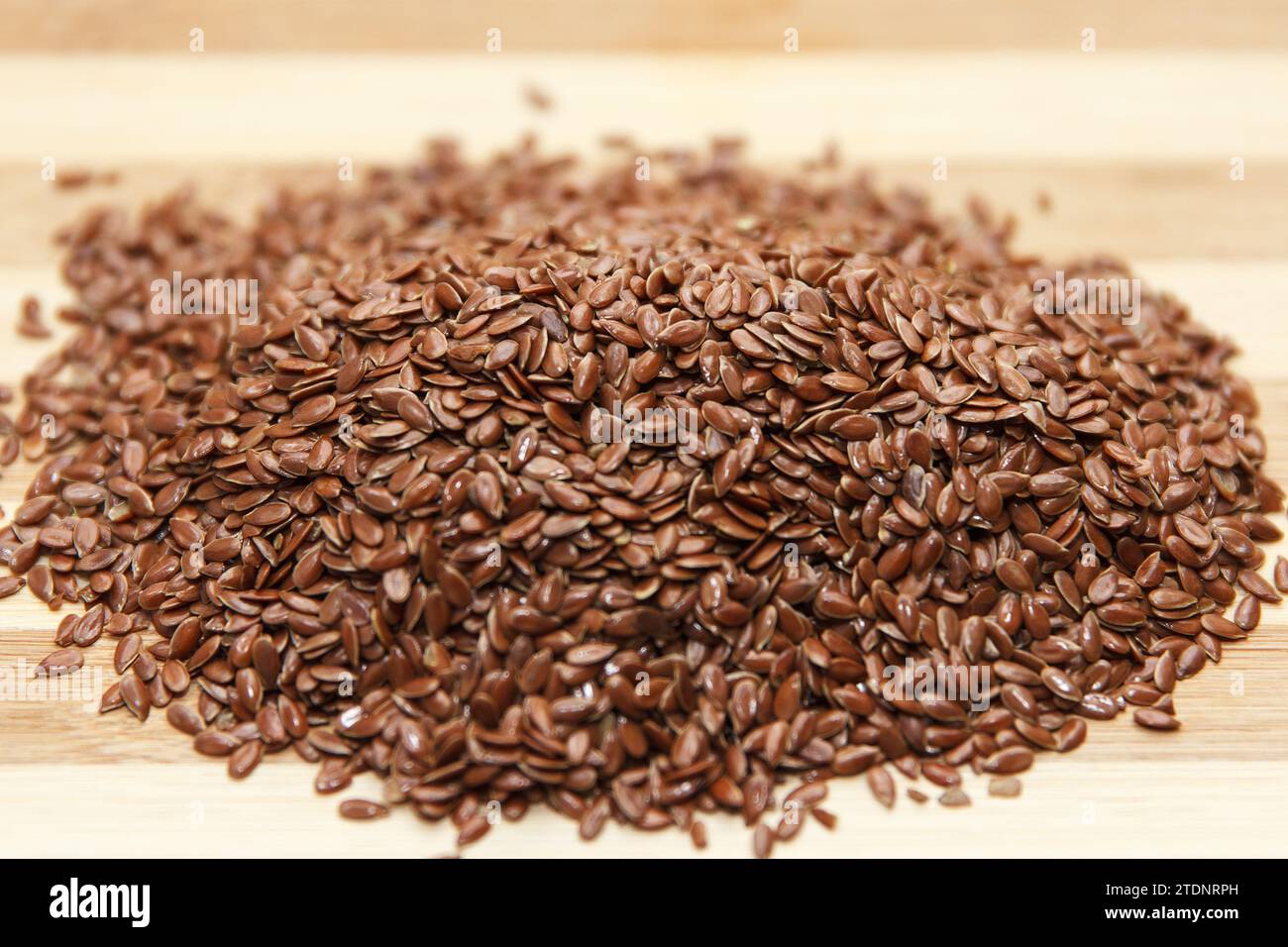 Les graines crues de lin reposent sur une surface en bois, préparées pour être utilisées en cuisine. Vue de dessus. Effectuer la mise au point au centre des grains Banque D'Images