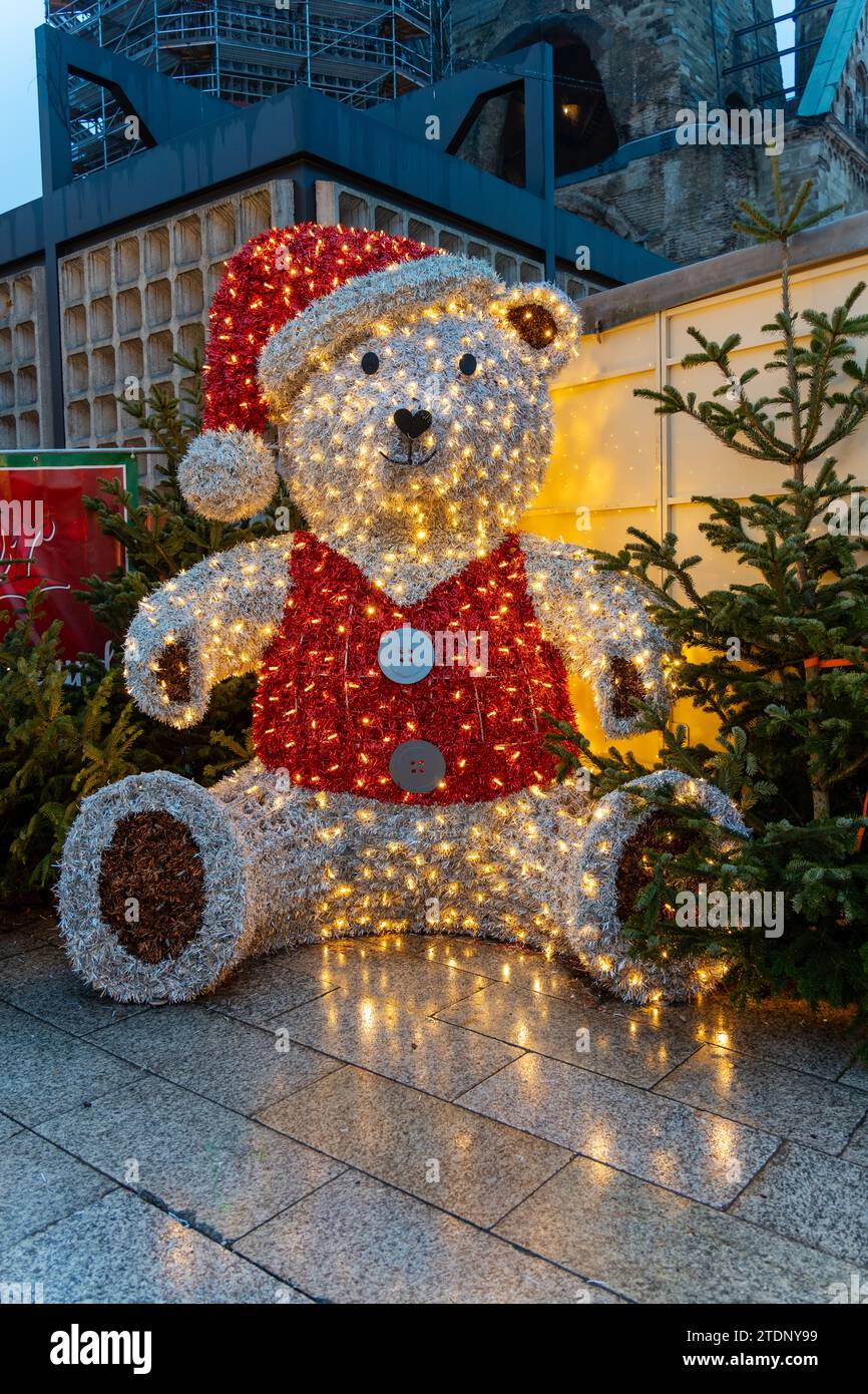 Un grand modèle illuminé d'ours polaire, habillé en Père Noël, dans un marché de Noël allemand traditionnel à Berlin, en Allemagne. Banque D'Images