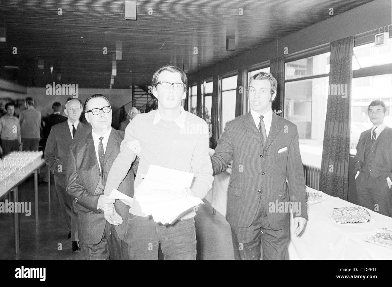 L'homme distribue des imprimés : Protest, à un public assis. Être escorté hors de l'espace, 00-03-1971, Whizgle News from the Past, taillé pour l'avenir. Explorez les récits historiques, l'image de l'agence néerlandaise avec une perspective moderne, comblant le fossé entre les événements d'hier et les perspectives de demain. Un voyage intemporel façonnant les histoires qui façonnent notre avenir Banque D'Images