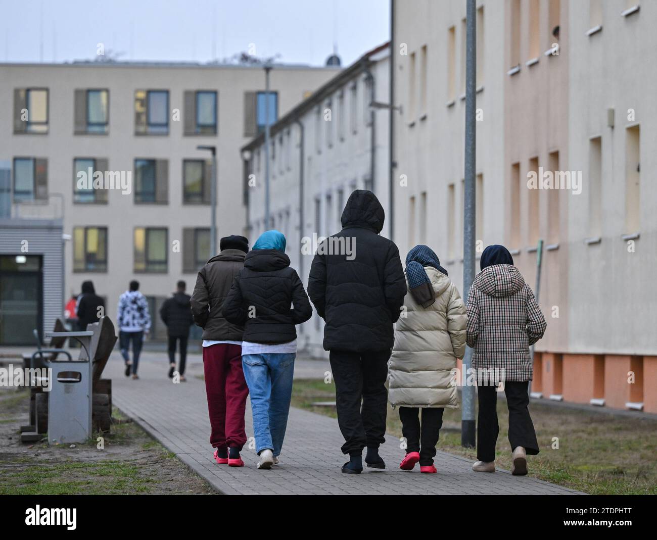 14 décembre 2023, Brandenburg, Eisenhüttenstadt : les migrants marchent sur le terrain du Centre central d'accueil pour demandeurs d'asile (ZABH) de l'État de Brandebourg à Eisenhüttenstadt. Photo : Patrick Pleul/dpa Banque D'Images