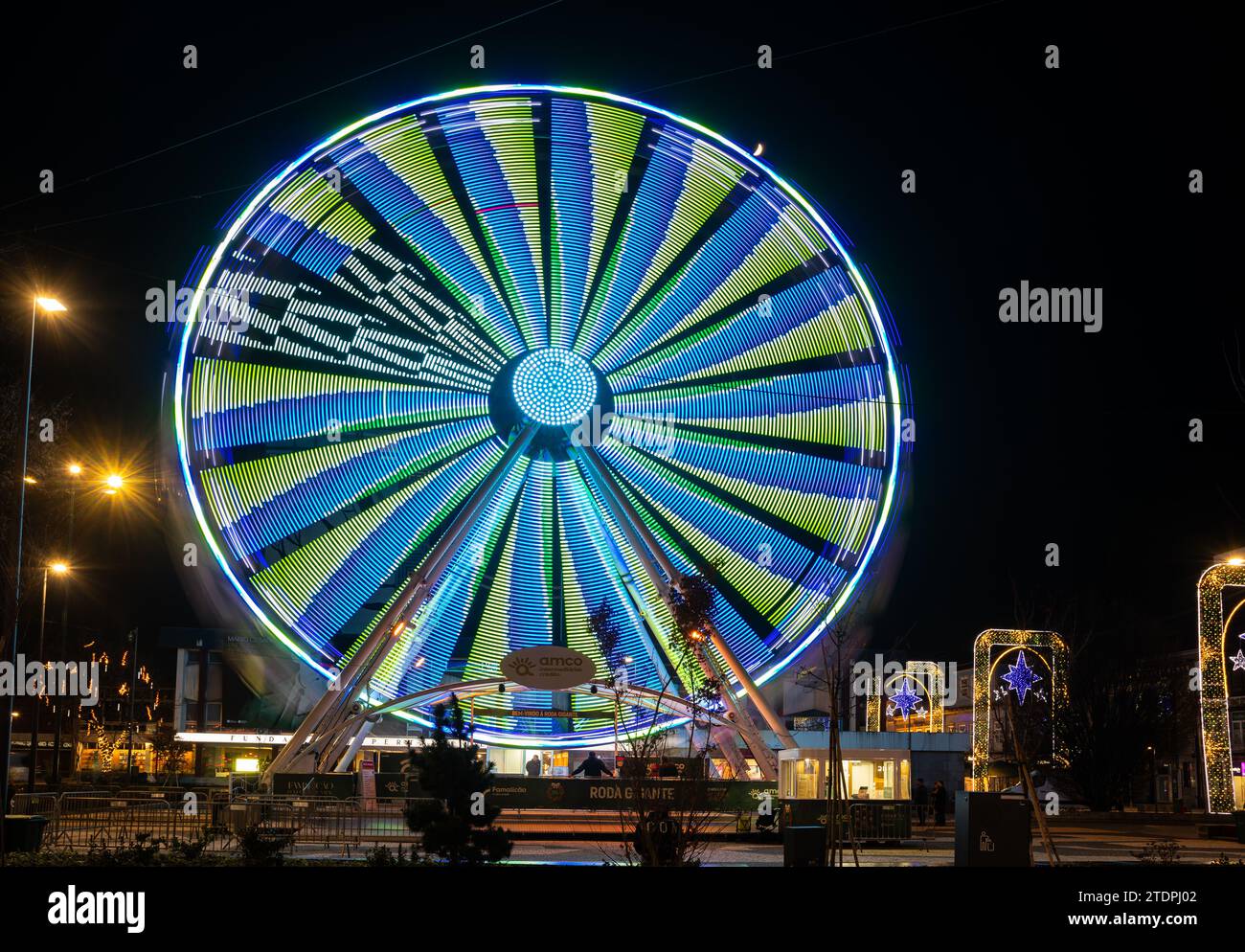 Famalicao, Portugal - 18 décembre 2023 : Grande grande grande roue dans le centre-ville de Famalicao et lampadaires de noël. Prise de vue longue exposition Banque D'Images