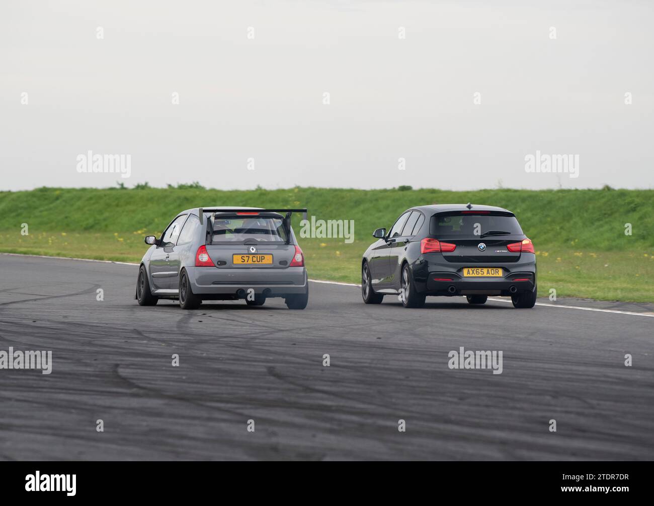 Clio Cup et BMW série 1 roulent vite sur piste lors d'une journée de course Banque D'Images