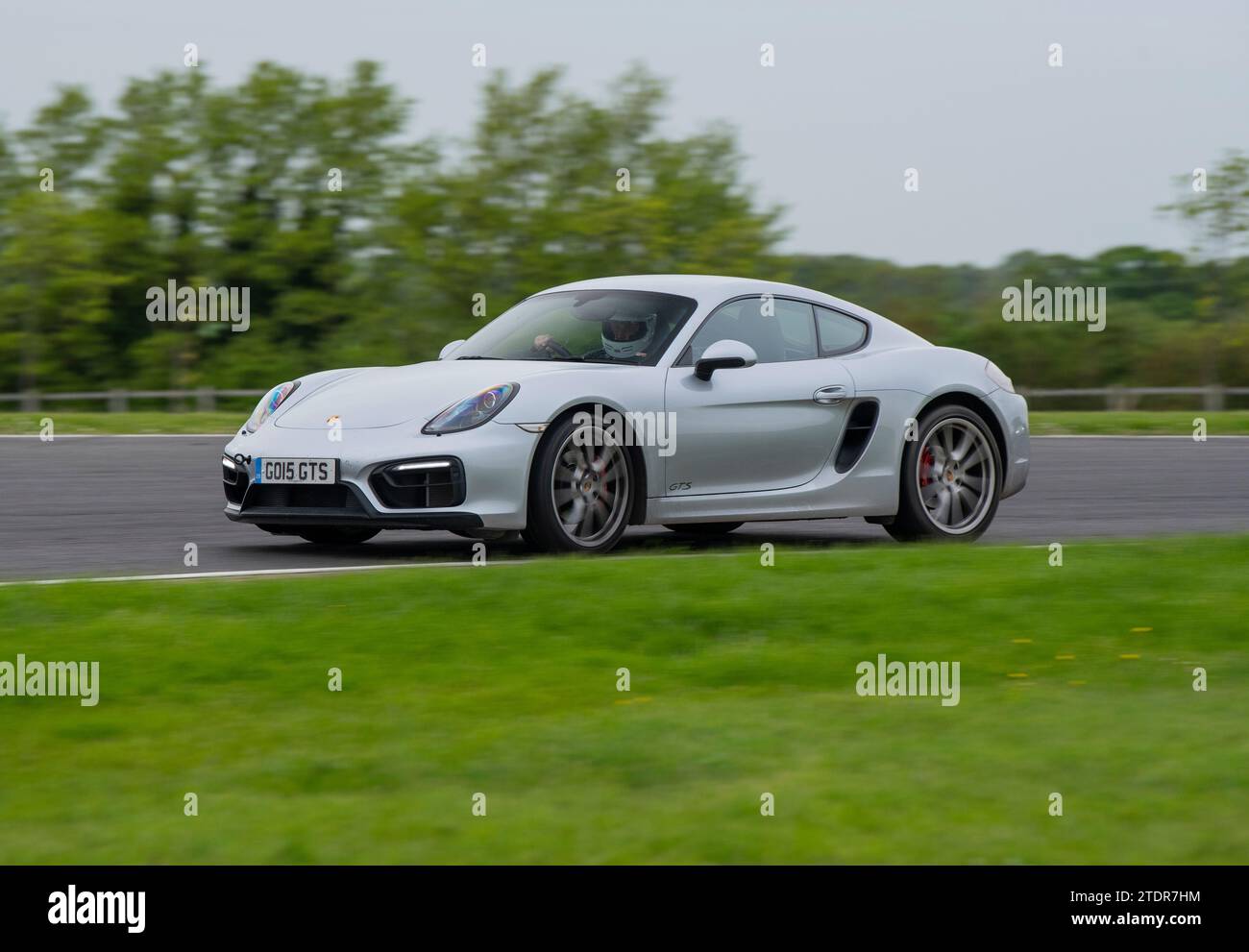 Porsche Cayman conduisant rapidement sur piste lors d'une course de jour Banque D'Images