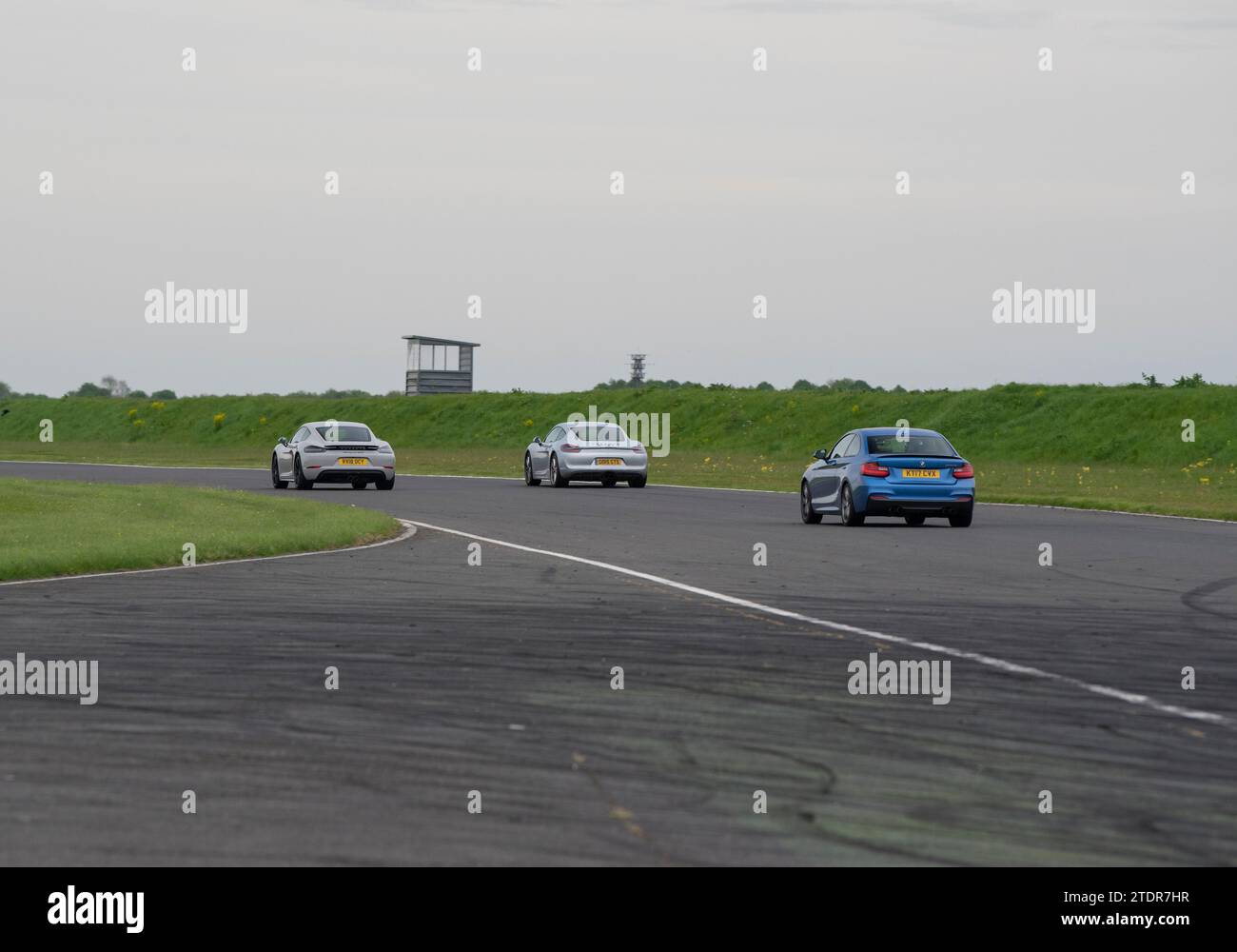2 Porsche Cayman et une BMW M3 voitures de sport conduisant rapidement sur piste lors d'une journée de course Banque D'Images