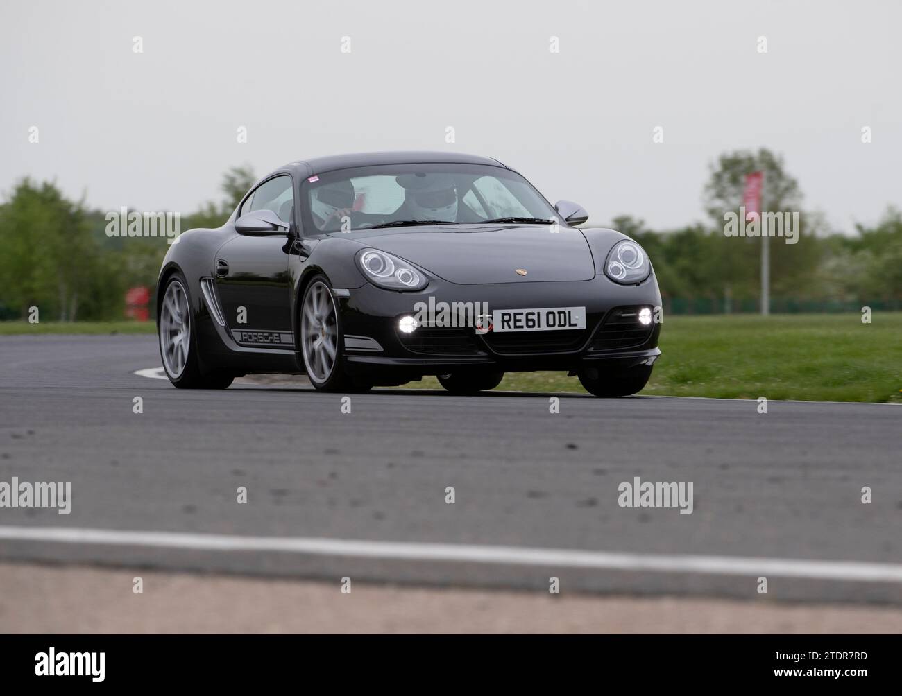 Porsche Cayman conduisant rapidement sur piste lors d'une course de jour Banque D'Images