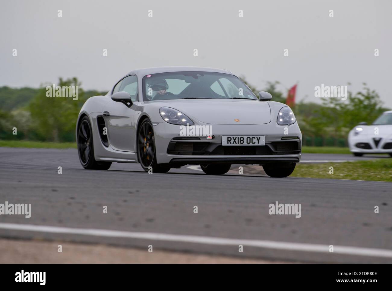 Porsche Cayman conduisant rapidement sur piste lors d'une course de jour Banque D'Images