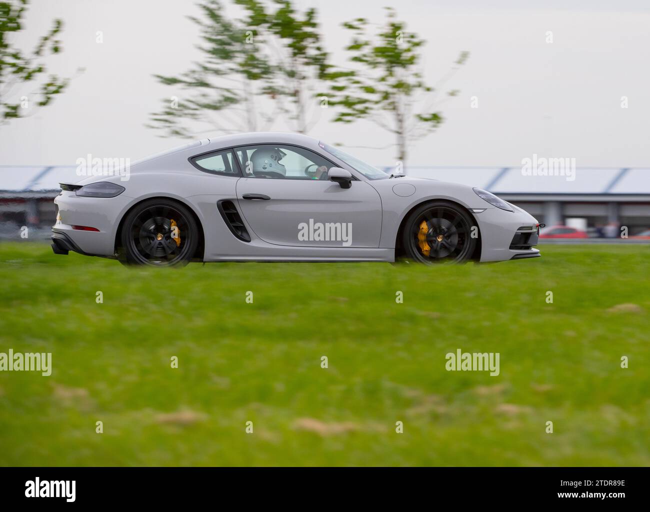 Porsche Cayman conduisant rapidement sur piste lors d'une course de jour Banque D'Images
