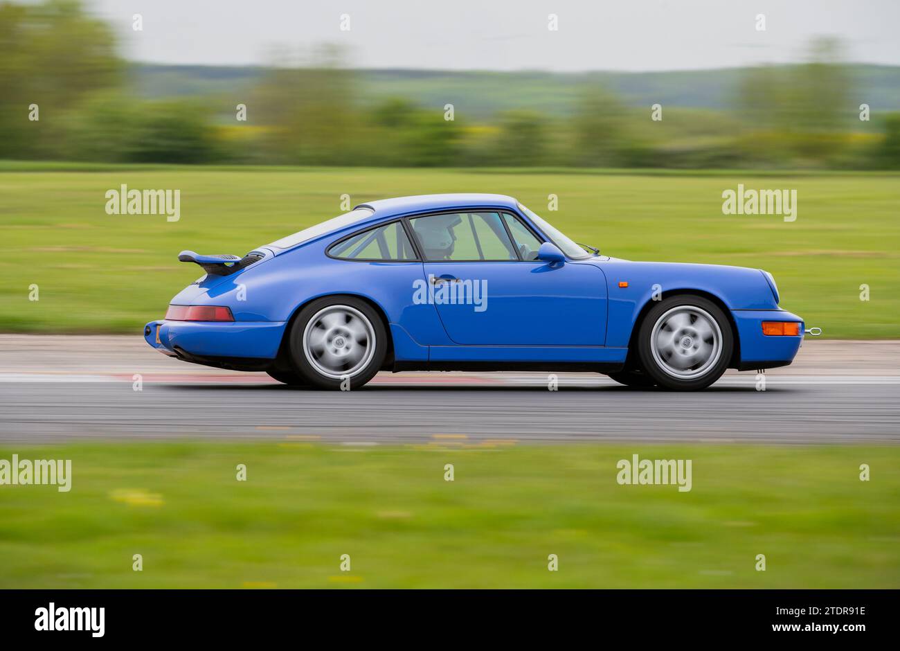 964 forme Porsche 911 conduisant rapidement sur piste lors d'un événement de jour de course Banque D'Images