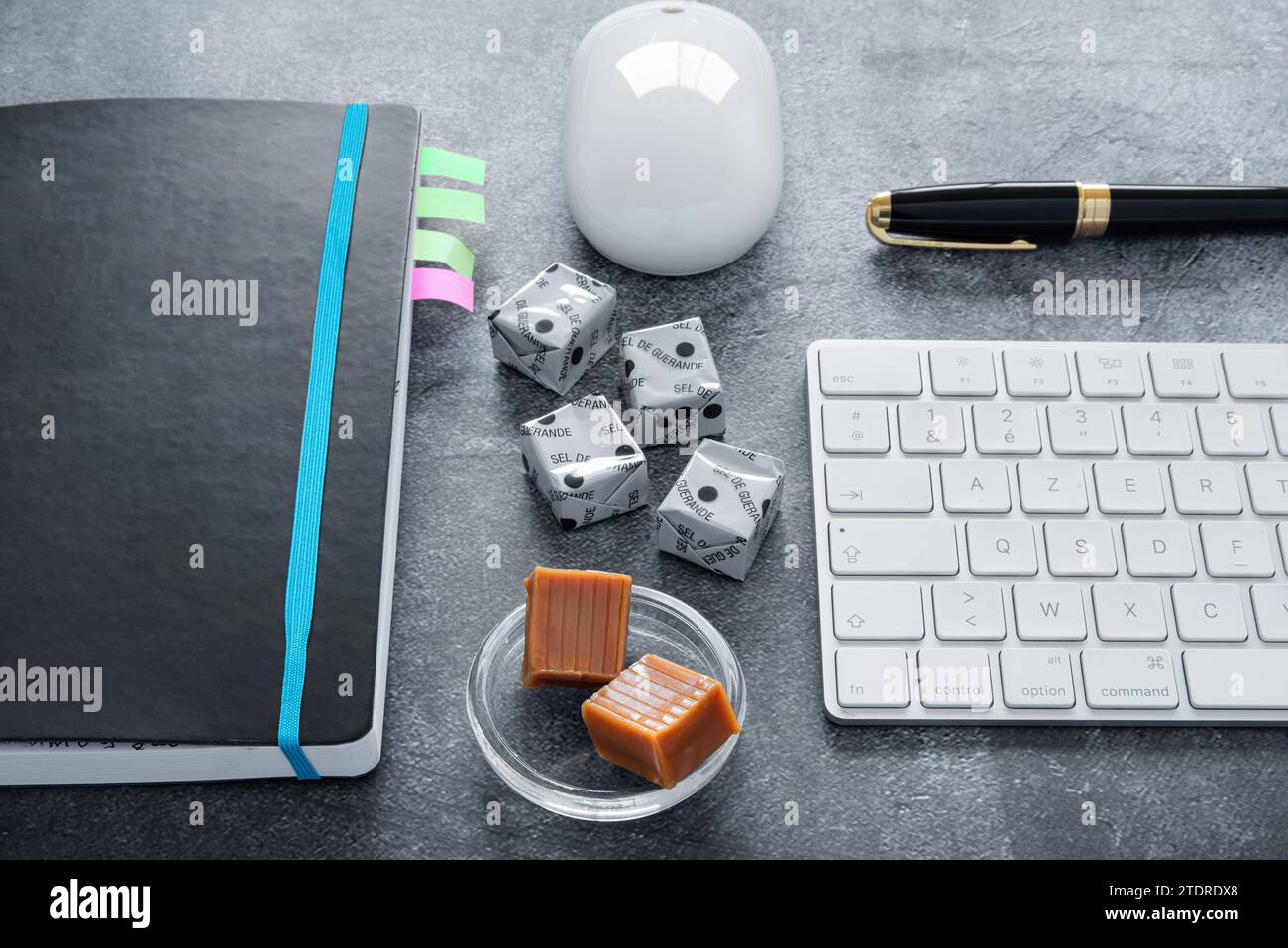 Pause café avec caramels sur un ordinateur au bureau ou pour les loisirs. Il est écrit en français 'Guérande sell' sur les petits carrés de confiserie Banque D'Images